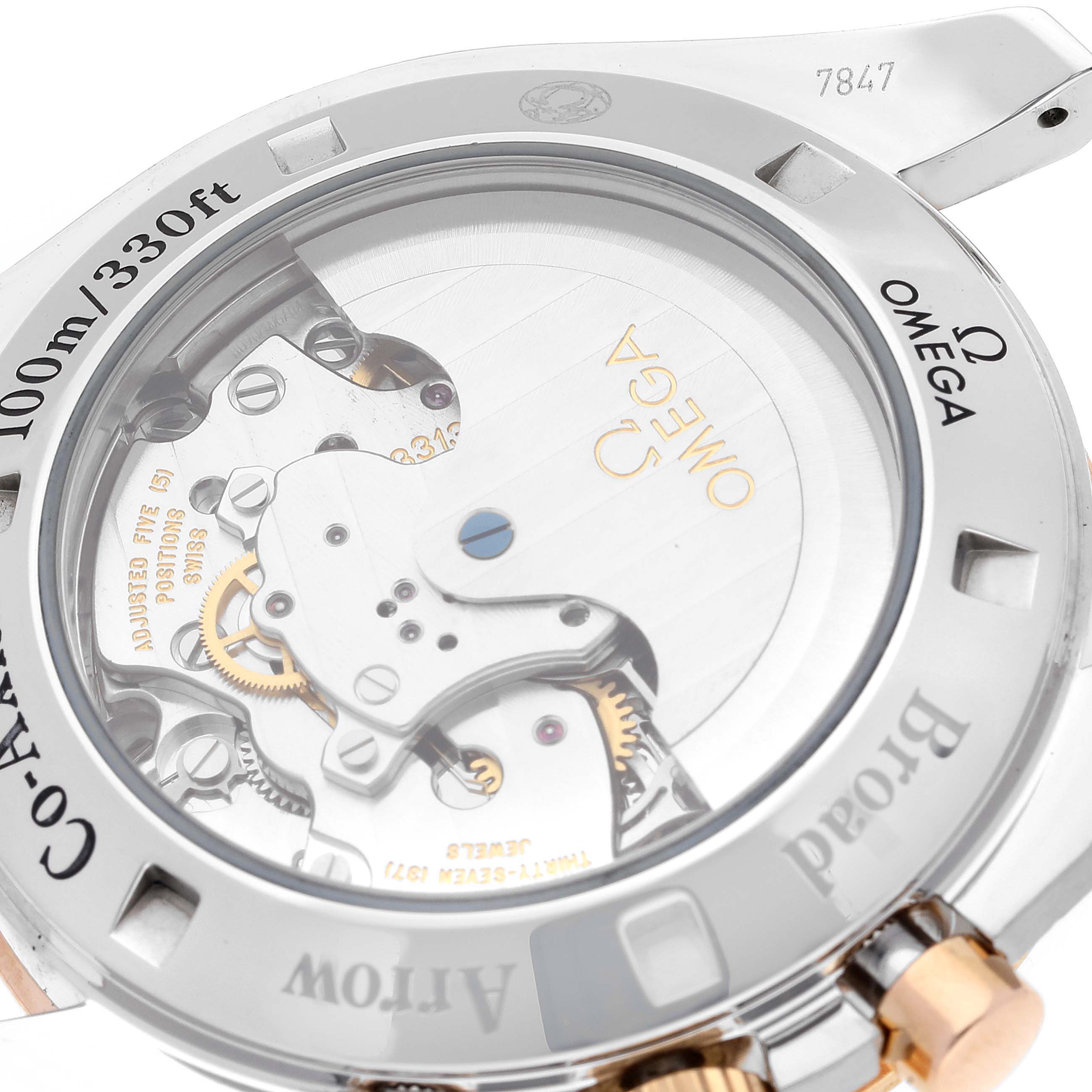 The image shows a close-up of the back view of an Omega Speedmaster 321.90.42.50.13.001 Men's Steel and Gold (two tone) Brown Dial 321.90.42.50.13.001 Men's Steel and Gold (two tone) Brown Dial, highlighting the movement and transparent case back.