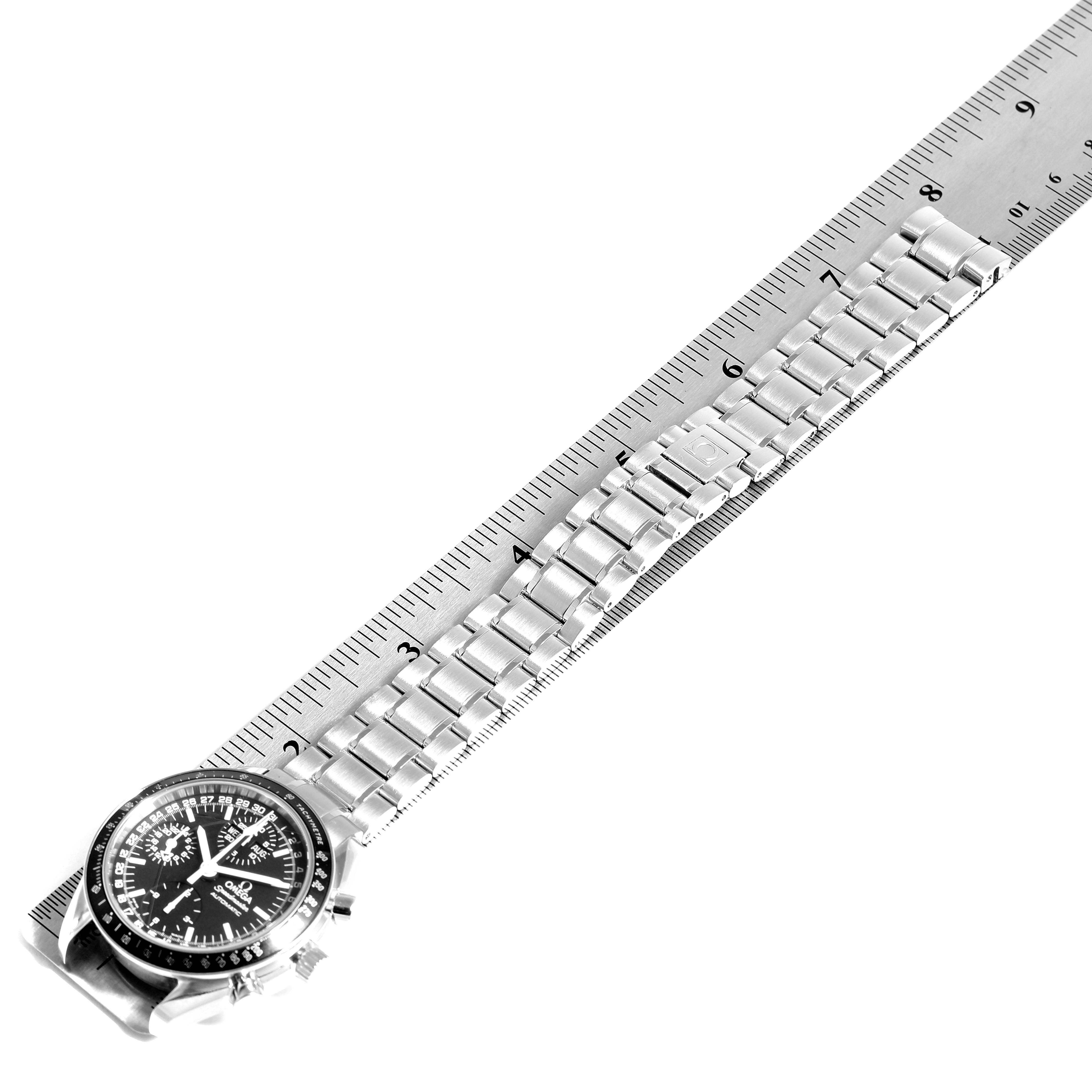 This image shows an Omega Speedmaster 3520.50.00 Men
s Stainless Steel Black Dial 3520.50.00 Men
s Stainless Steel Black Dial watch laid flat with its metal bracelet aligned next to a ruler.