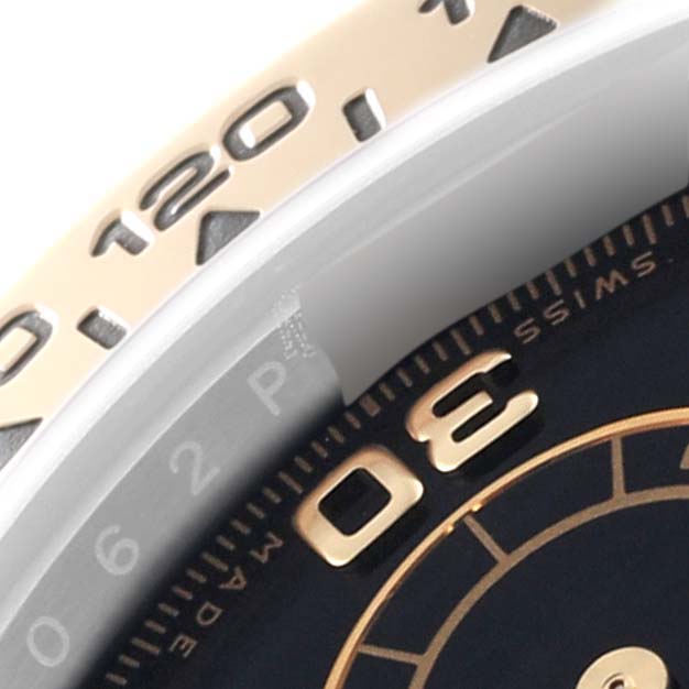 The image shows a close-up of the bezel and part of the dial of a Rolex Daytona 116503 Men
s Steel and Gold (two tone) Black Dial 116503 Men
s Steel and Gold (two tone) Black Dial watch.