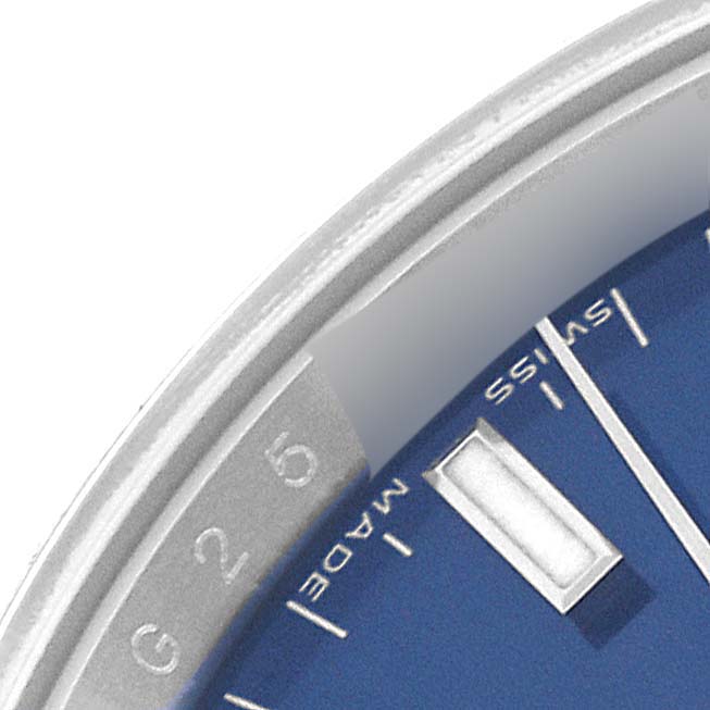The image shows a close-up of the Rolex Date 115200 Men's Stainless Steel Blue Dial 115200 Men's Stainless Steel Blue Dial model watch, highlighting its blue dial and part of the bezel with "Swiss Made" text.