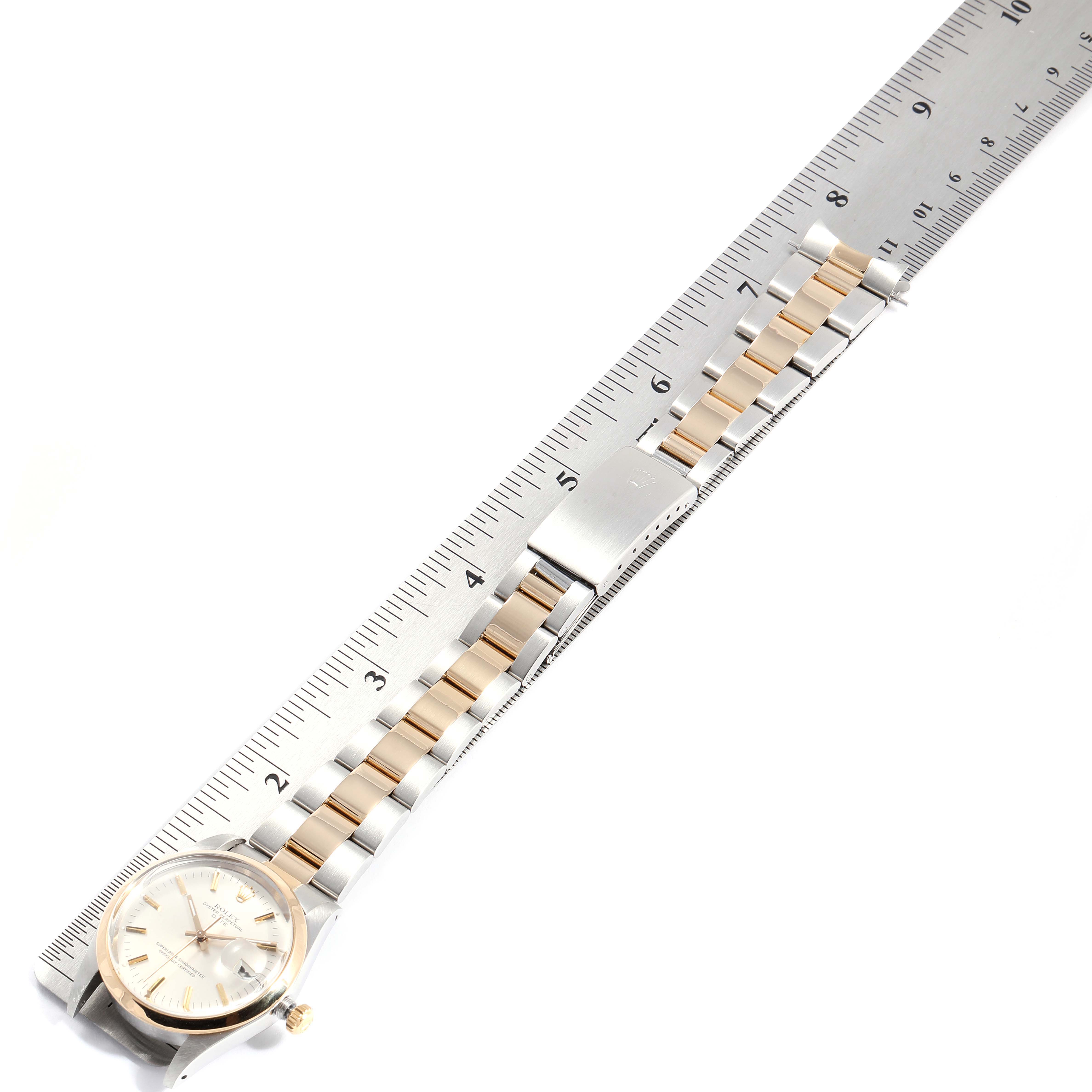 This image shows a Rolex Vintage Collection 15003 Men's Steel and Gold (two tone) Silver Dial 15003 Men's Steel and Gold (two tone) Silver Dial watch laid flat, displaying its band, clasp, and face, alongside a ruler for scale.