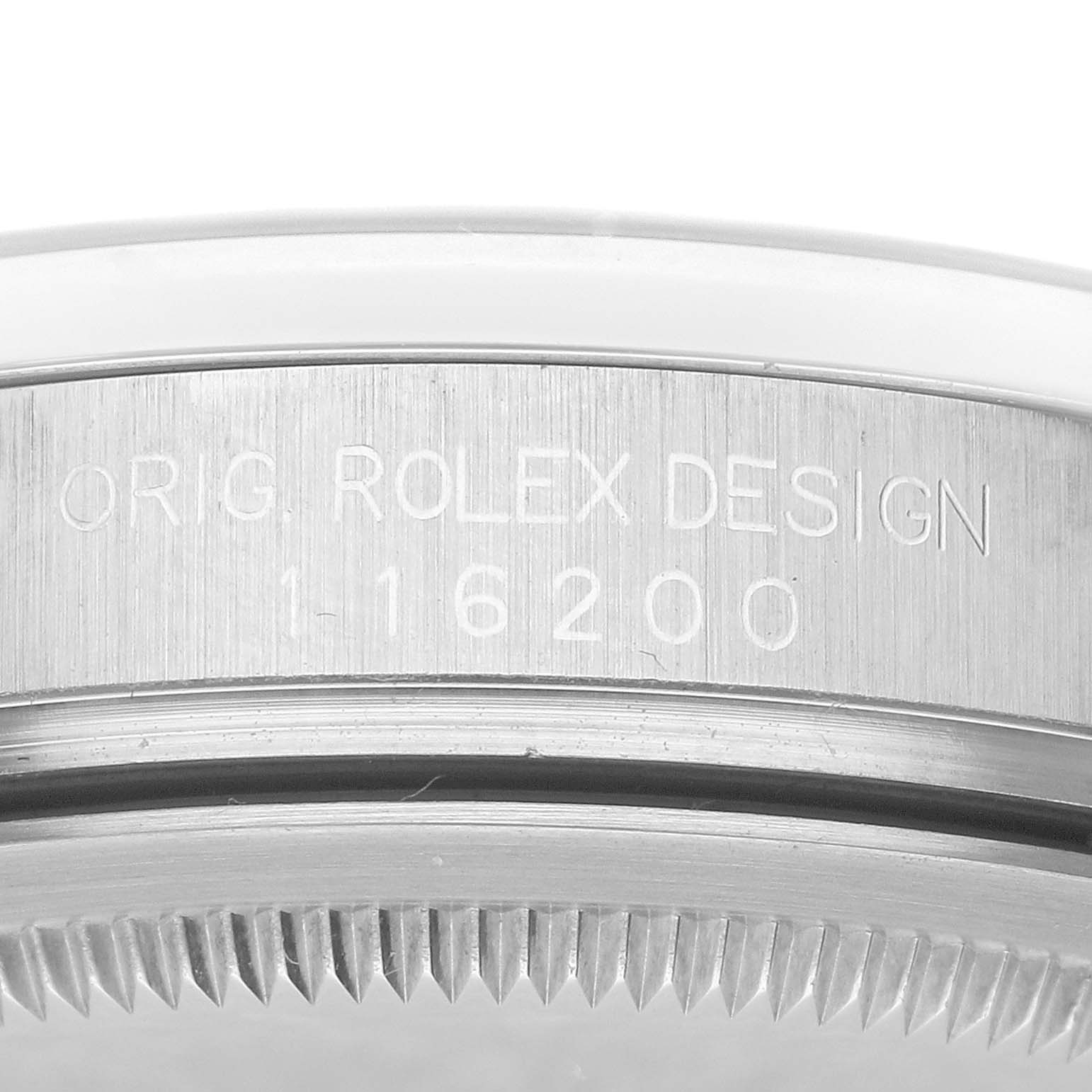 The image shows a close-up of the side engraving and serrated edge on a Rolex Datejust 116200 Men's Stainless Steel Black Dial 116200 Men's Stainless Steel Black Dial model.