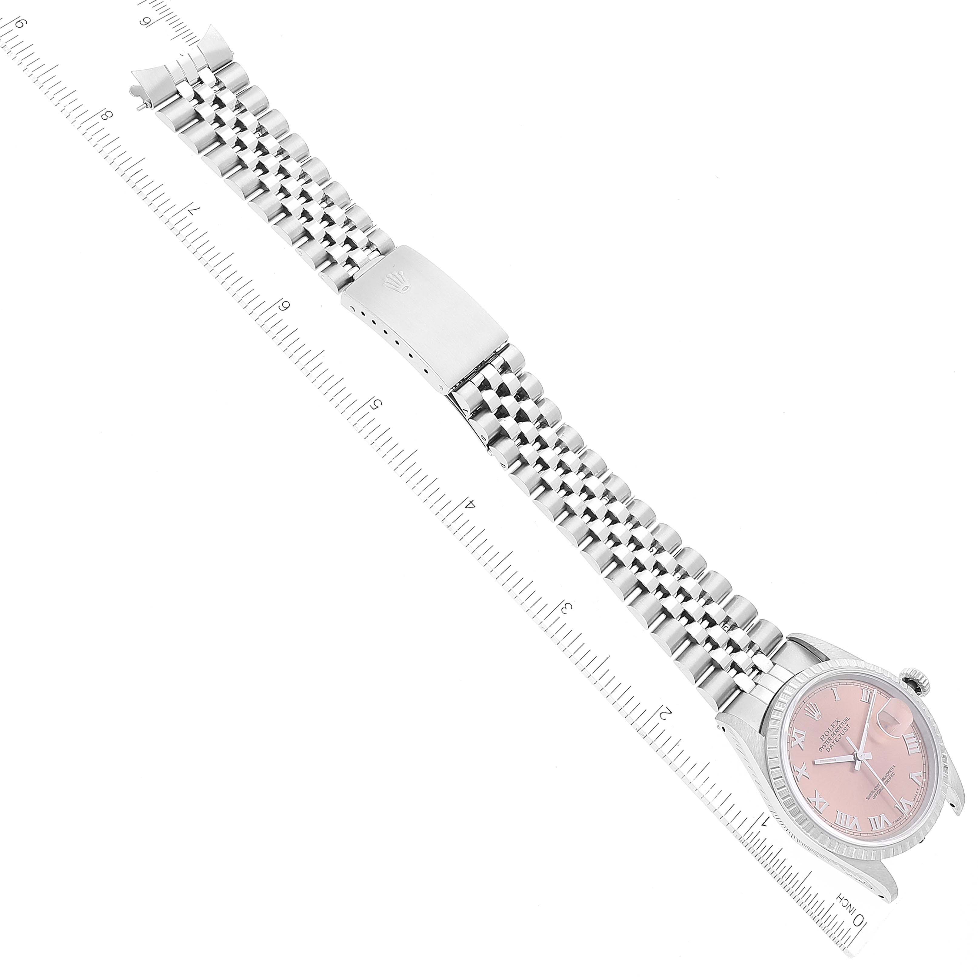 The image shows a Rolex Datejust 16220 Men's Stainless Steel Pink Dial 16220 Men's Stainless Steel Pink Dial watch at a diagonal top view, highlighting its pink dial, Jubilee bracelet, and clasp alongside a ruler.