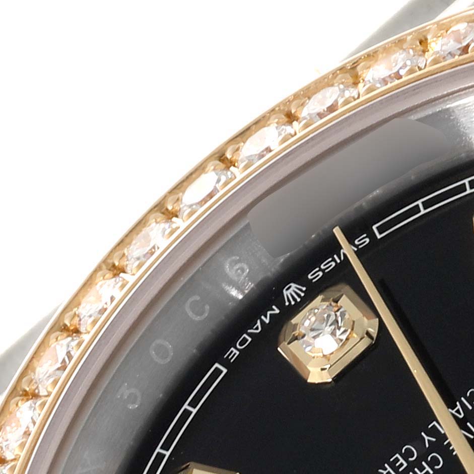 This close-up image shows the bezel and dial of a Rolex Datejust M126283RBR-0003 Men's Steel and Gold (two tone) Black Dial M126283RBR-0003 Men's Steel and Gold (two tone) Black Dial watch, highlighted with diamond accents.