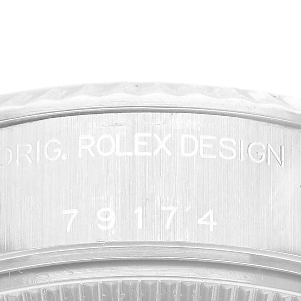 This image shows a close-up of the side engravings on a Rolex Datejust 79174 Women's Stainless Steel Blue Dial 79174 Women's Stainless Steel Blue Dial watch, displaying the model number and "Rolex Design."
