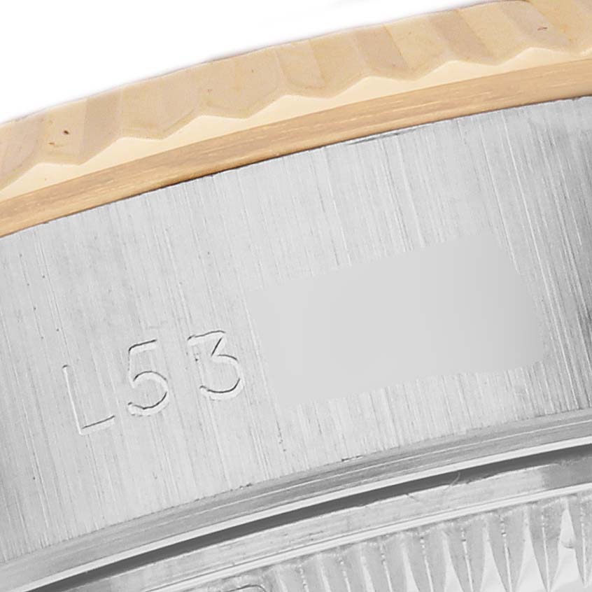 This close-up image shows the partial engraving and fluted bezel of a Rolex Datejust 69173 Women's Steel and Gold (two tone) Beige Dial 69173 Women's Steel and Gold (two tone) Beige Dial watch.