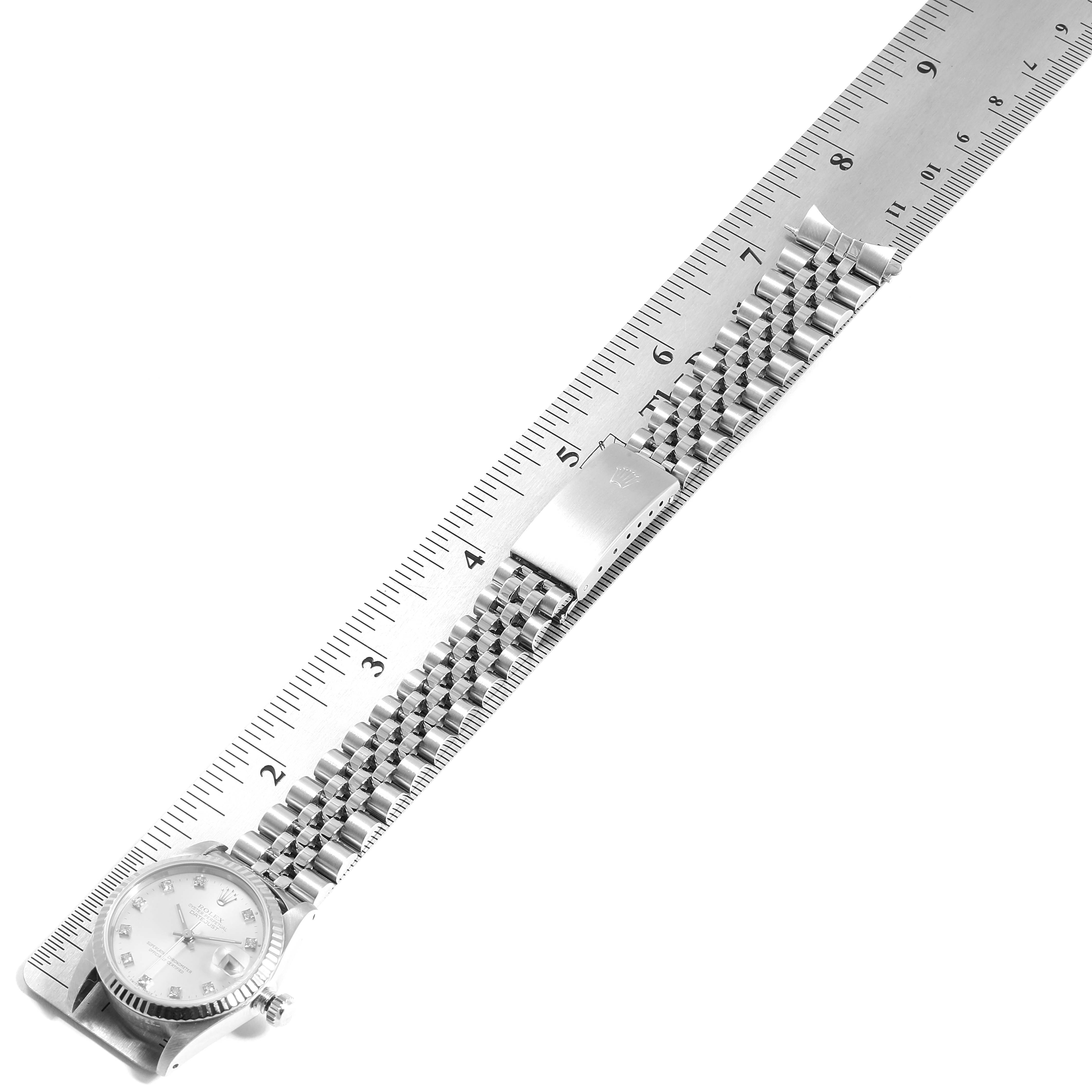 The image shows the front view of the Rolex Datejust 68274 Women's Stainless Steel Silver Dial 68274 Women's Stainless Steel Silver Dial watch lying flat next to a ruler, displaying its bracelet and clasp.
