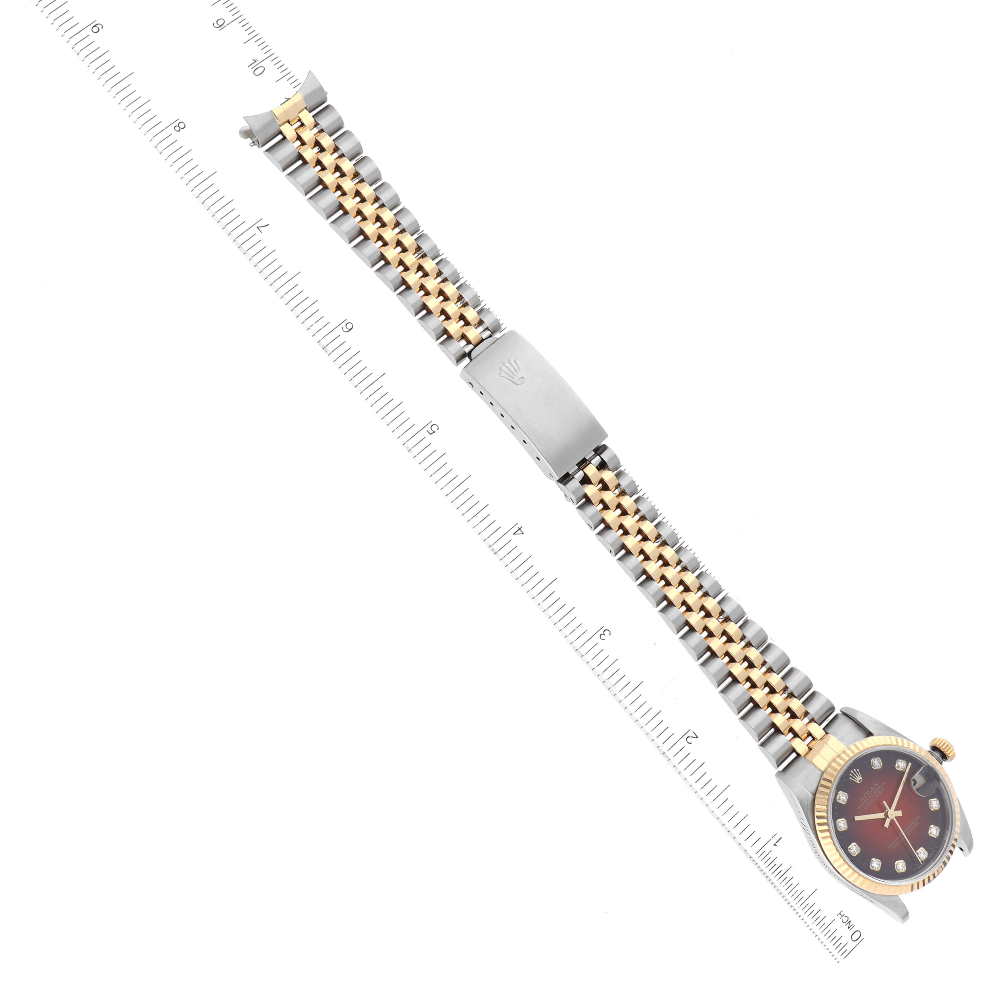 The Rolex Mid-Size 78273 Women's Steel and Gold (two tone) Red Dial 78273 Women's Steel and Gold (two tone) Red Dial watch is shown from a top-down angle, displaying the bracelet, clasp, and part of the dial.