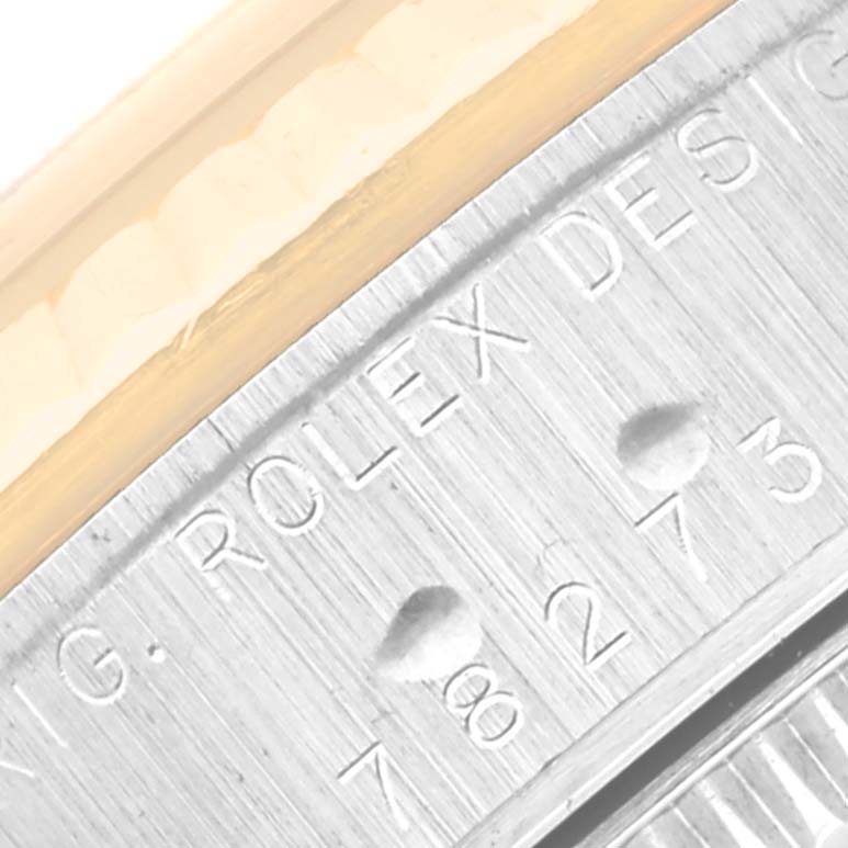 The image shows a close-up of the bezel and engraved details of a Mid-Size model Rolex watch.