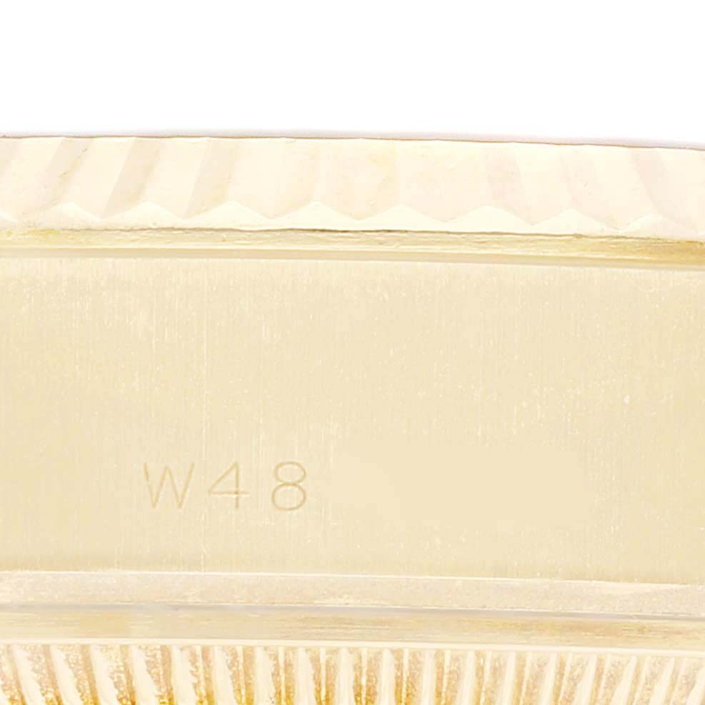 This close-up image shows the side of a Rolex President 69178 Women's Yellow Gold Beige Dial 69178 Women's Yellow Gold Beige Dial model watch, highlighting the serial number and part of the fluted bezel.