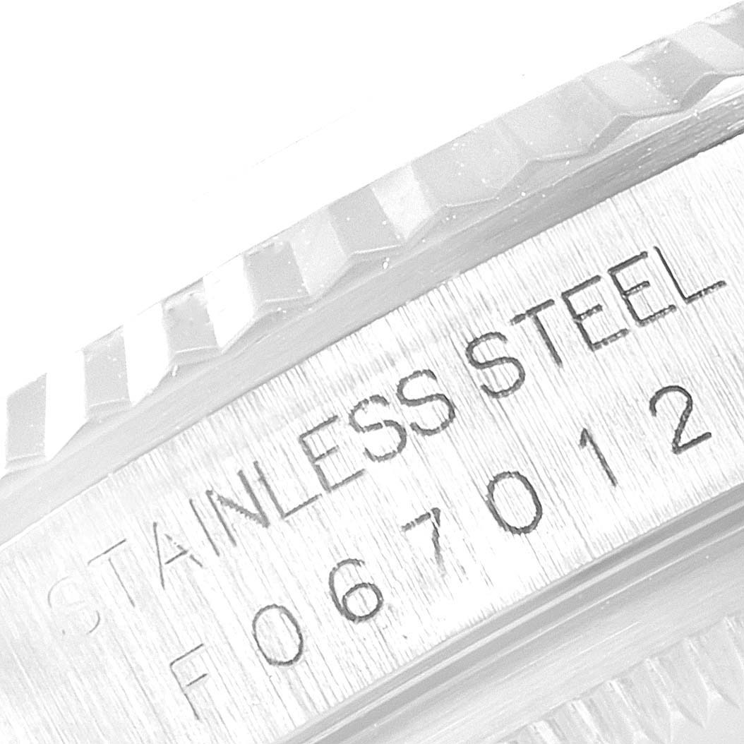 The image shows a close-up angle of the case and fluted bezel of a Rolex Datejust 16234 Men
s Stainless Steel Blue Dial 16234 Men
s Stainless Steel Blue Dial, with "STAINLESS STEEL" and a serial number engraved.