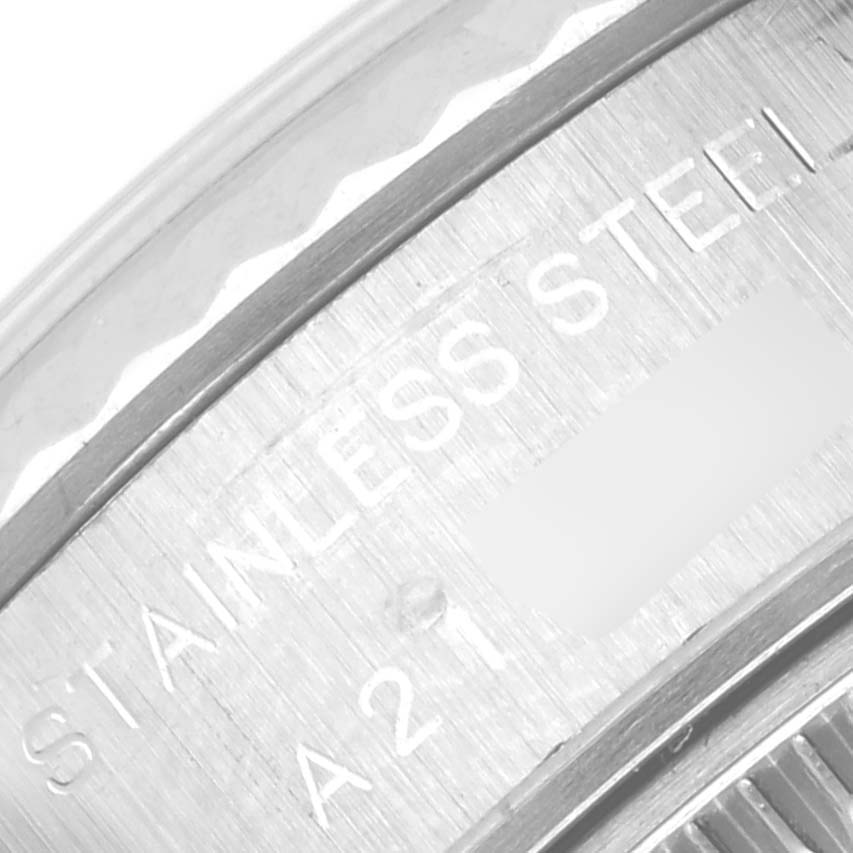 The image shows a macro shot of the case back edges and part of the engravings of a Rolex Datejust 79174 Women's Stainless Steel Mother of Pearl Dial 79174 Women's Stainless Steel Mother of Pearl Dial model watch, indicating "STAINLESS STEEL".
