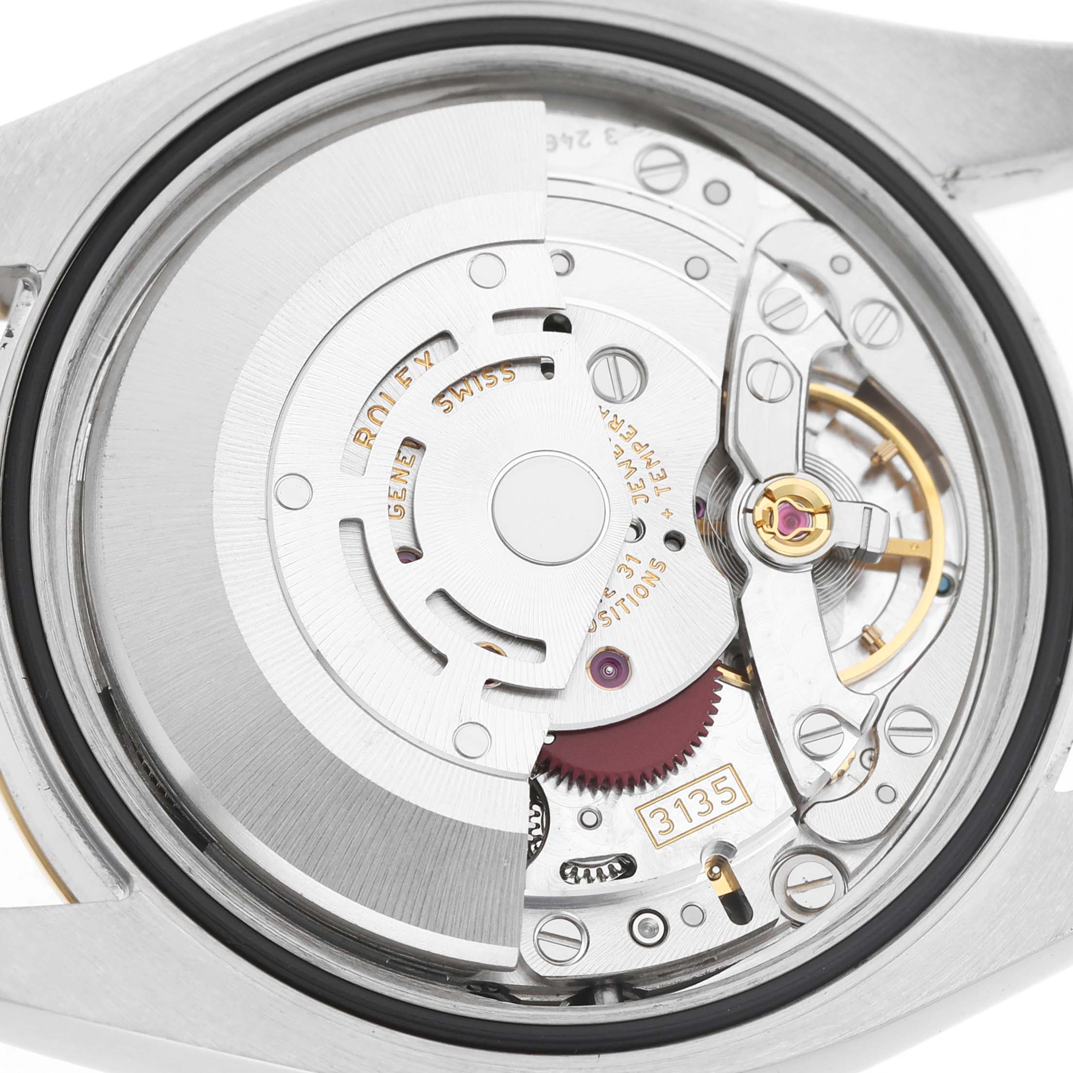The image shows a close-up of the Rolex Datejust 116233 Men's Steel and Gold (two tone) Black Dial's movement, showcasing intricate gears and components from the back.