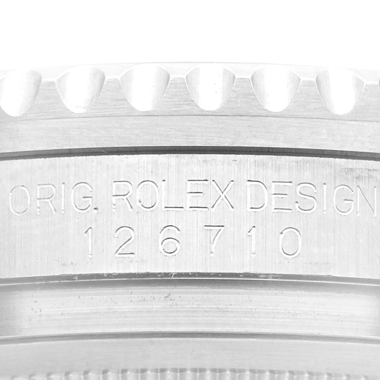This close-up image shows the side engraving on a Rolex GMT-Master 126710BLNR Men's Stainless Steel Black Dial 126710BLNR Men's Stainless Steel Black Dial watch, featuring the words "ORIG. ROLEX DESIGN" and the model number "126710."