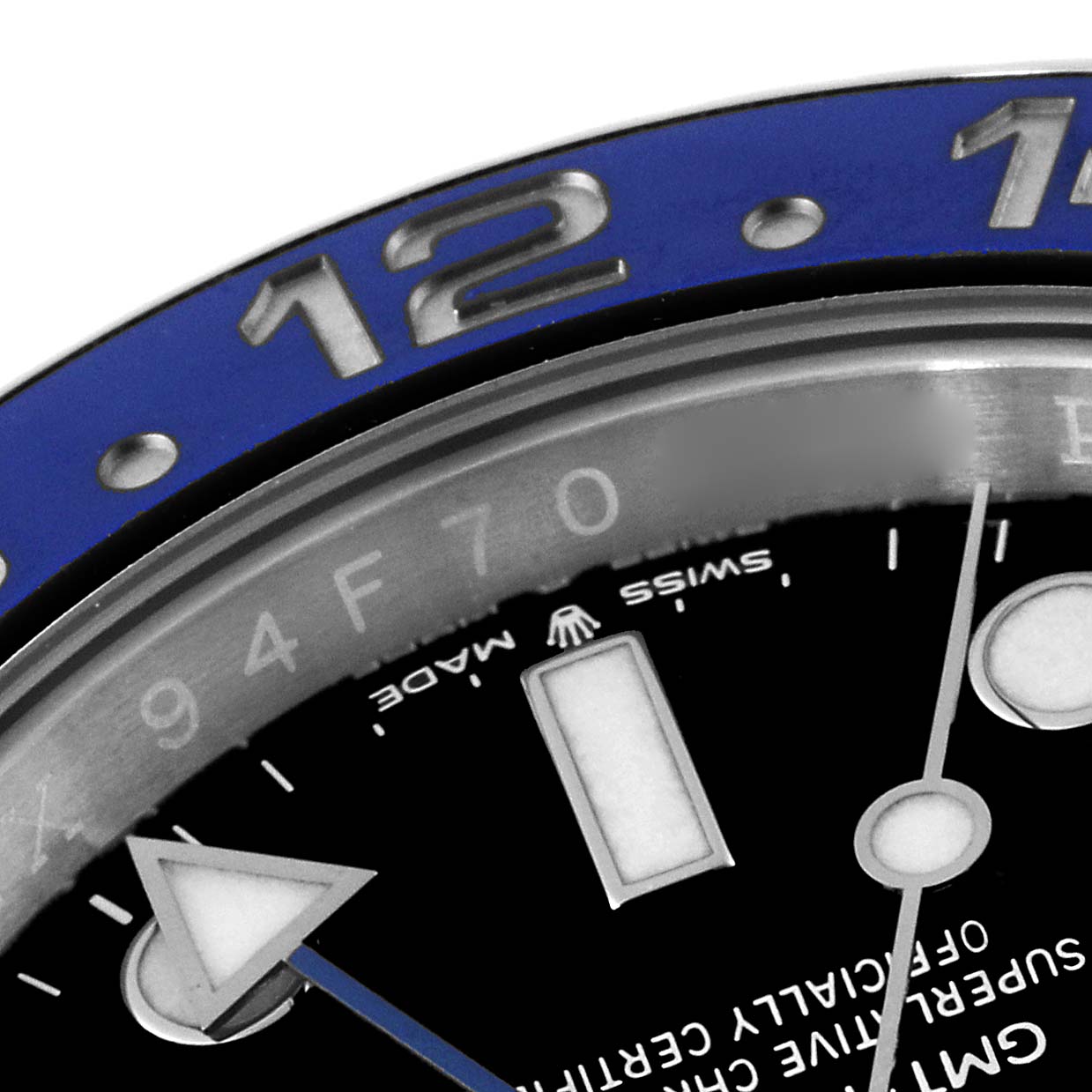 This image shows a close-up of the bezel, dial, and hands of a Rolex GMT-Master 126710BLNR Men's Stainless Steel Black Dial 126710BLNR Men's Stainless Steel Black Dial watch, highlighting the "12" marker and part of the Swiss Made text.