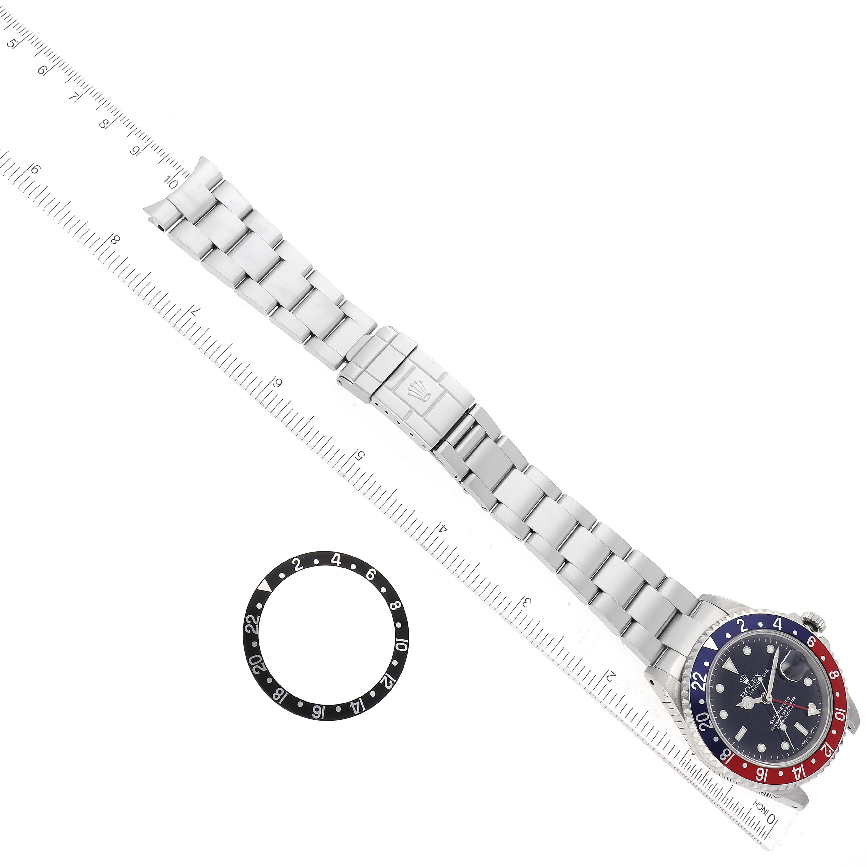 The image shows a top view of a Rolex GMT-Master 16710 Men's Stainless Steel Black Dial 16710 Men's Stainless Steel Black Dial watch with its bracelet extended and an additional bezel insert.