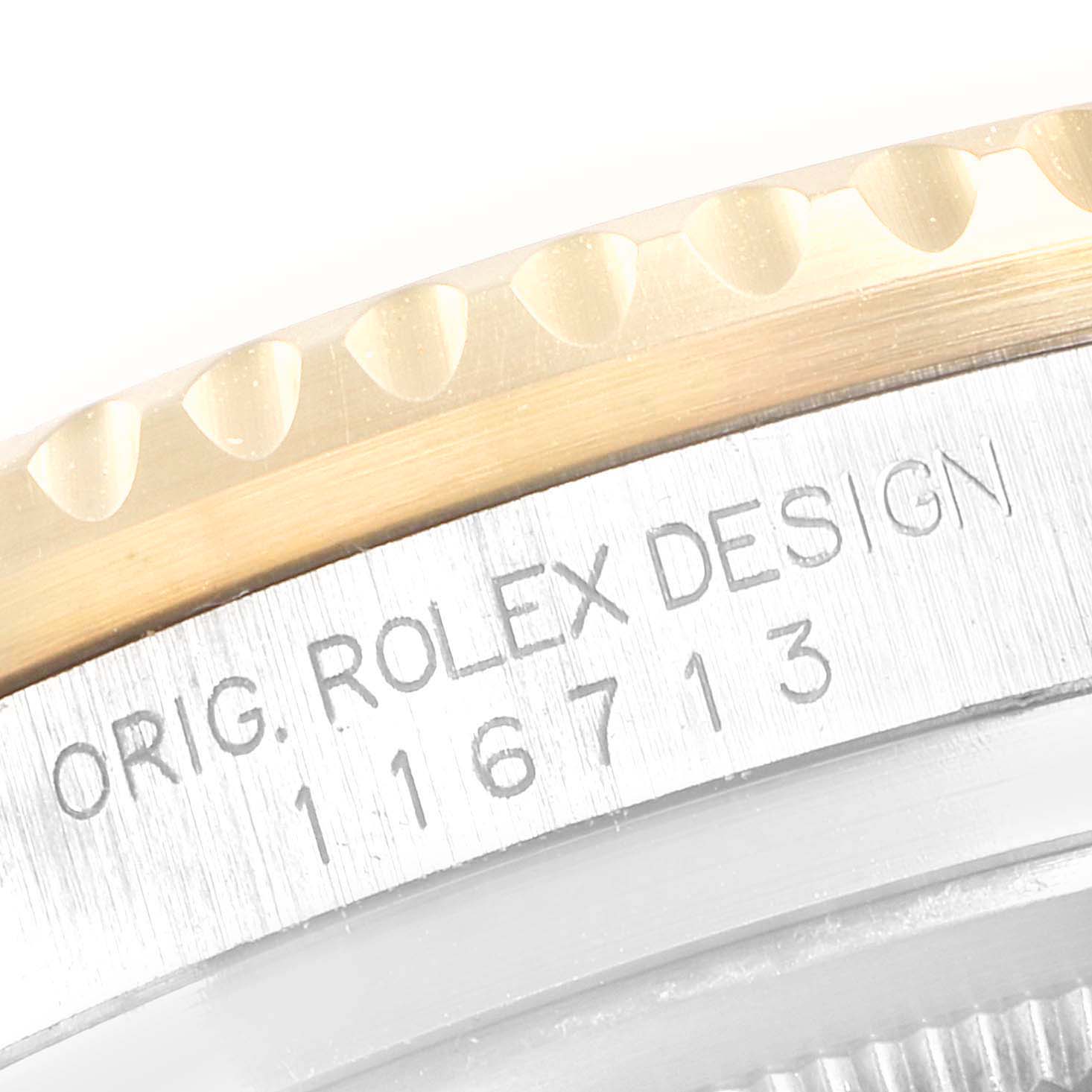 The image shows a close-up of the engraved side of a Rolex GMT-Master M116713LN Men's Steel and Gold (two tone) Black Dial watch, focusing on the bezel and case.