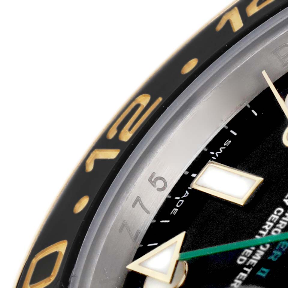This close-up shows part of the bezel, dial, and a hand of the Rolex GMT-Master M116713LN Men's Steel and Gold (two tone) Black Dial.