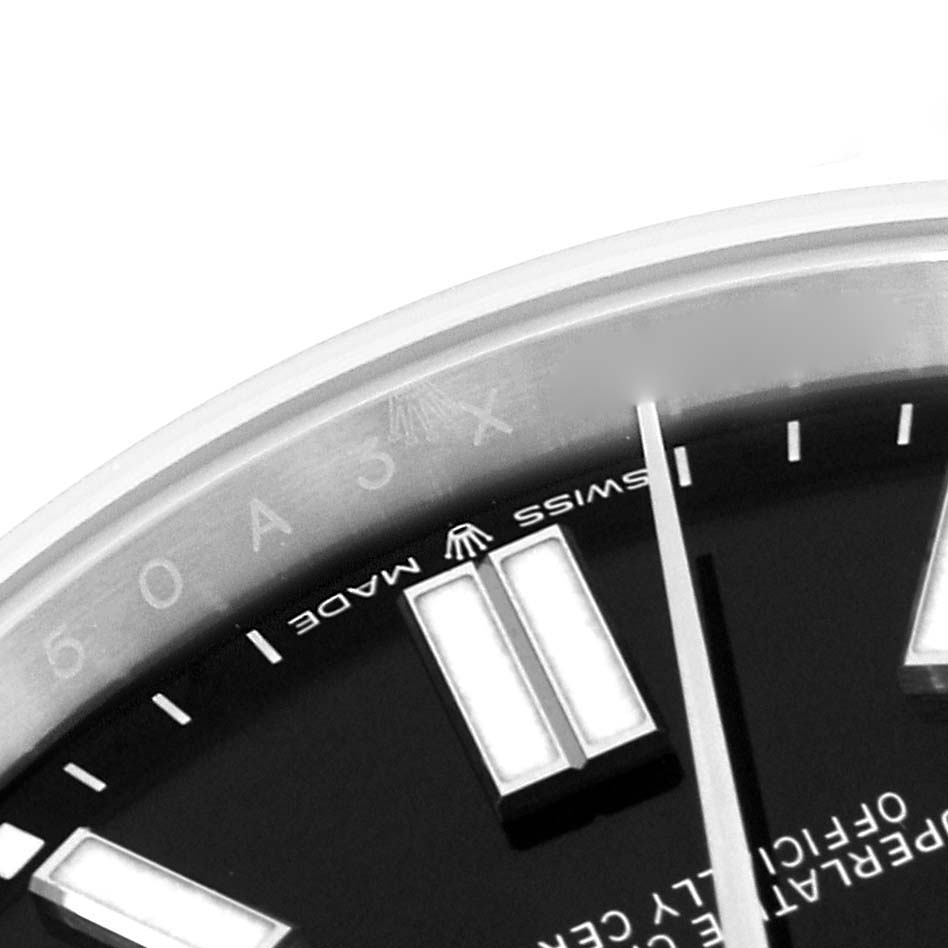 This close-up image of a Rolex Oyster Perpetual 124300 Men's Stainless Steel Black Dial 124300 Men's Stainless Steel Black Dial watch shows part of the dial and some hour markers.