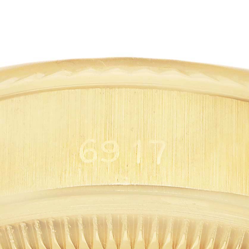 The image shows a close-up of the side of a Rolex President 6917 Women's Yellow Gold Champagne Dial model, focusing on the case detailing and engravings.