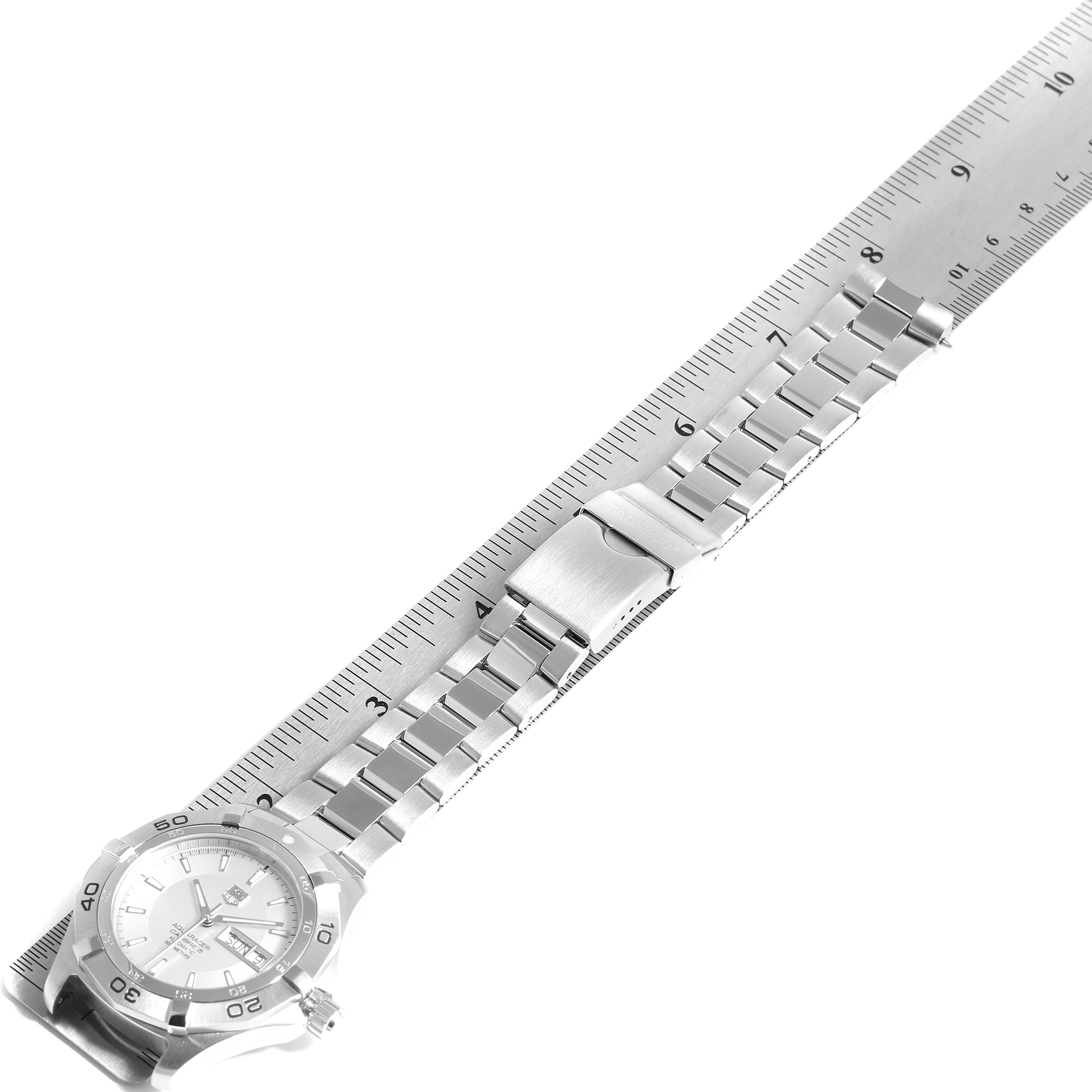 The image shows a Tag Heuer Aquaracer WAF2011.BA0818 Men's Stainless Steel Silver Dial WAF2011.BA0818 Men's Stainless Steel Silver Dial watch positioned next to a ruler, displaying the metallic strap and clasp from an overhead angle.