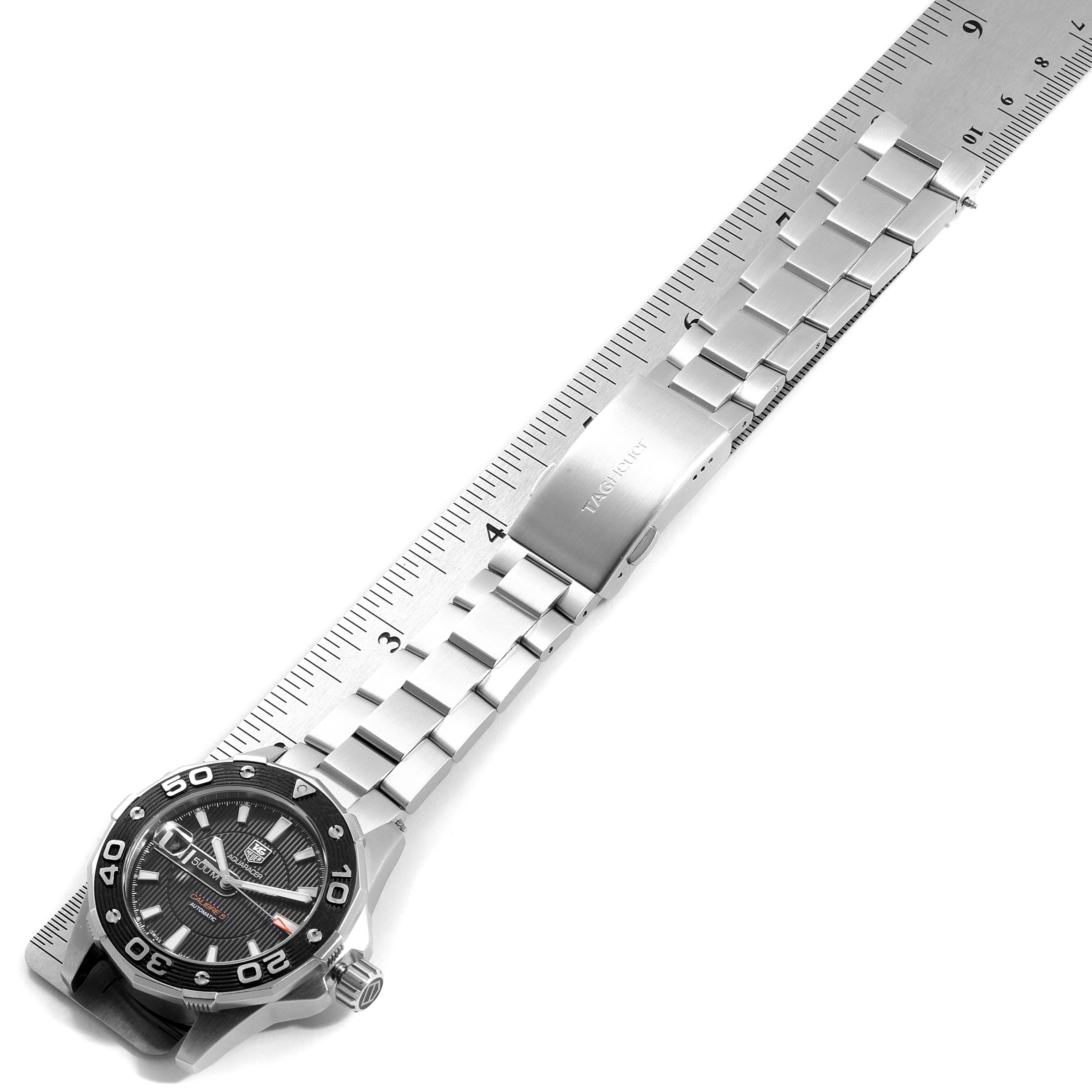 The image shows a Tag Heuer Aquaracer WAJ2110.BA0870 Men's Stainless Steel Black Dial WAJ2110.BA0870 Men's Stainless Steel Black Dial watch laid flat with its face, bracelet, and clasp aligned next to a ruler.