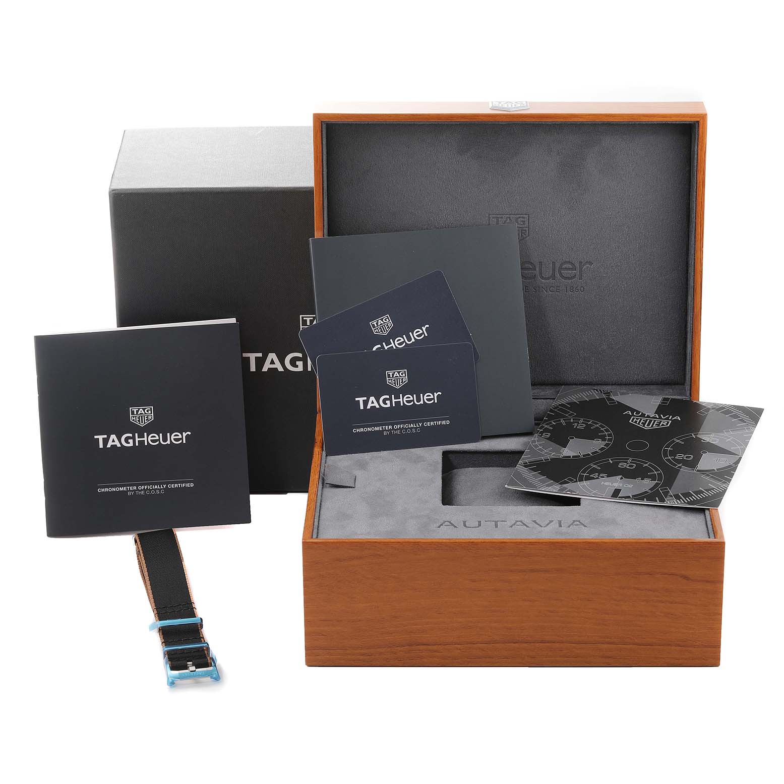 The image shows the packaging, paperwork, and an extra strap for the Autavia model by Tag Heuer.