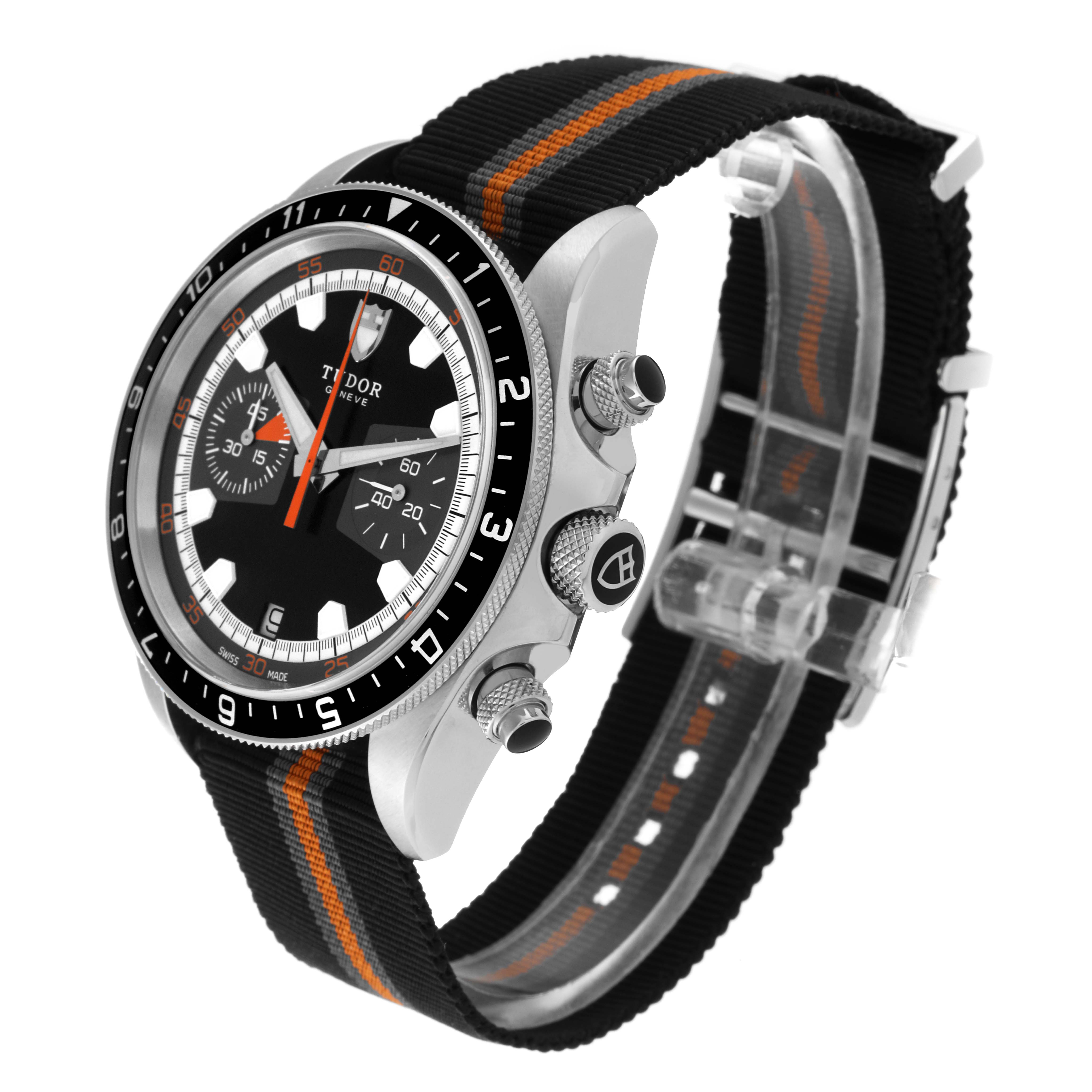 The image shows a side angle of the Tudor Heritage Chrono 70330N Men's Stainless Steel Grey Dial 70330N Men's Stainless Steel Grey Dial watch, highlighting the crown, pushers, and black strap with orange accents.