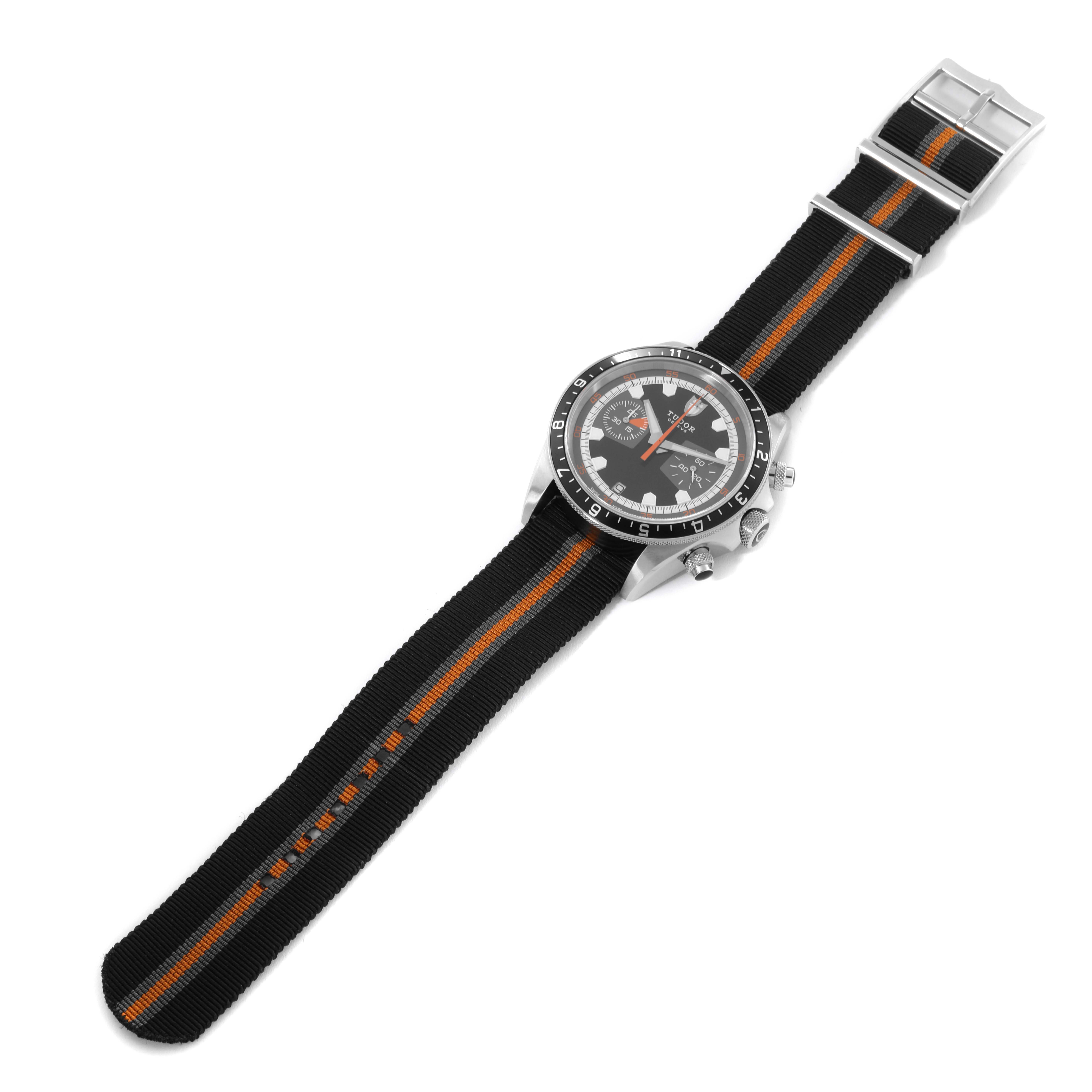 The image shows a Tudor Heritage Chrono 70330N Men's Stainless Steel Grey Dial 70330N Men's Stainless Steel Grey Dial watch, with a focus on the black and orange NATO strap and the watch face, viewed from above.
