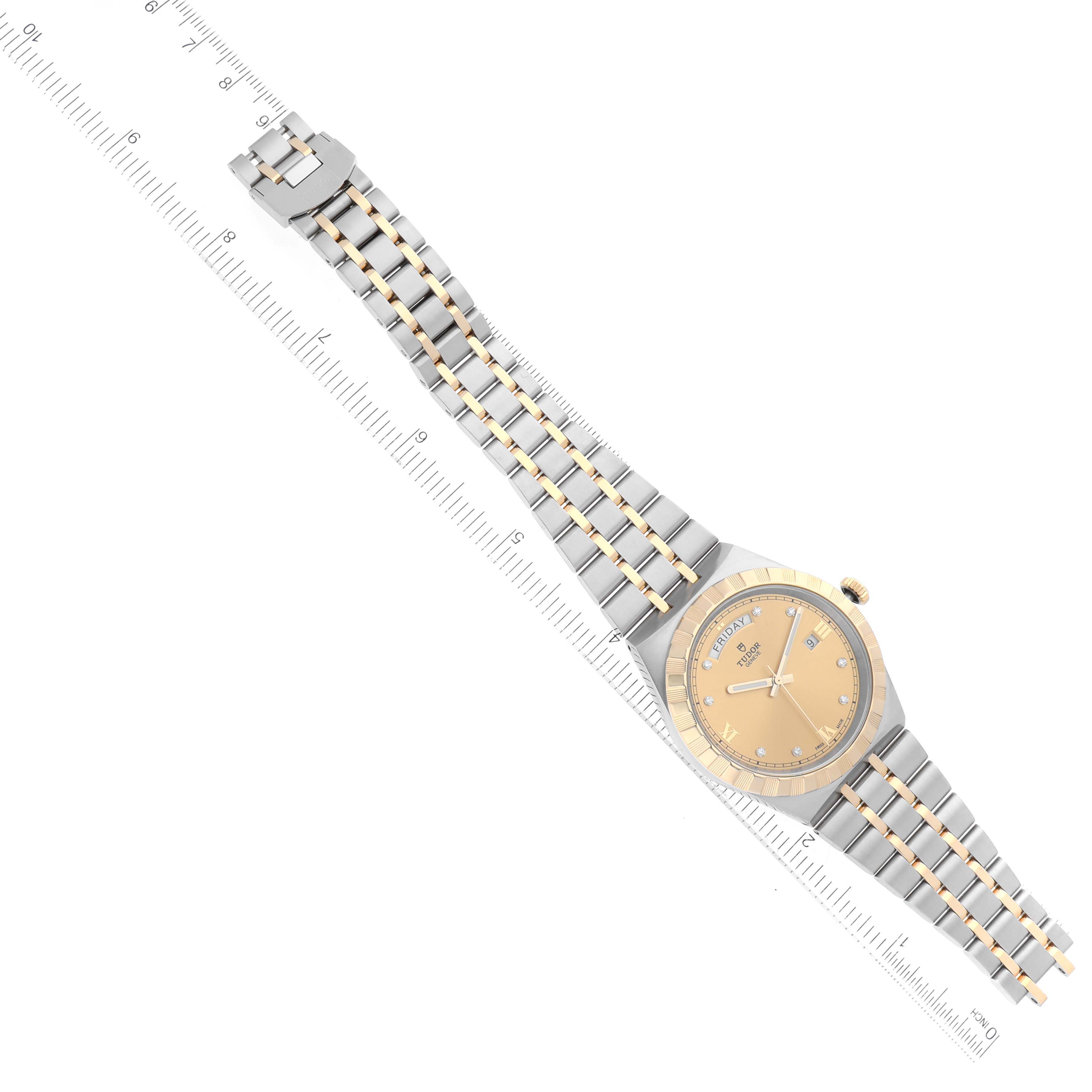 The image shows a Tudor Royal 28603 Men's Steel and Gold (two tone) Champagne Dial 28603 Men's Steel and Gold (two tone) Champagne Dial watch angled along a ruler, displaying its dial, crown, and two-tone bracelet.
