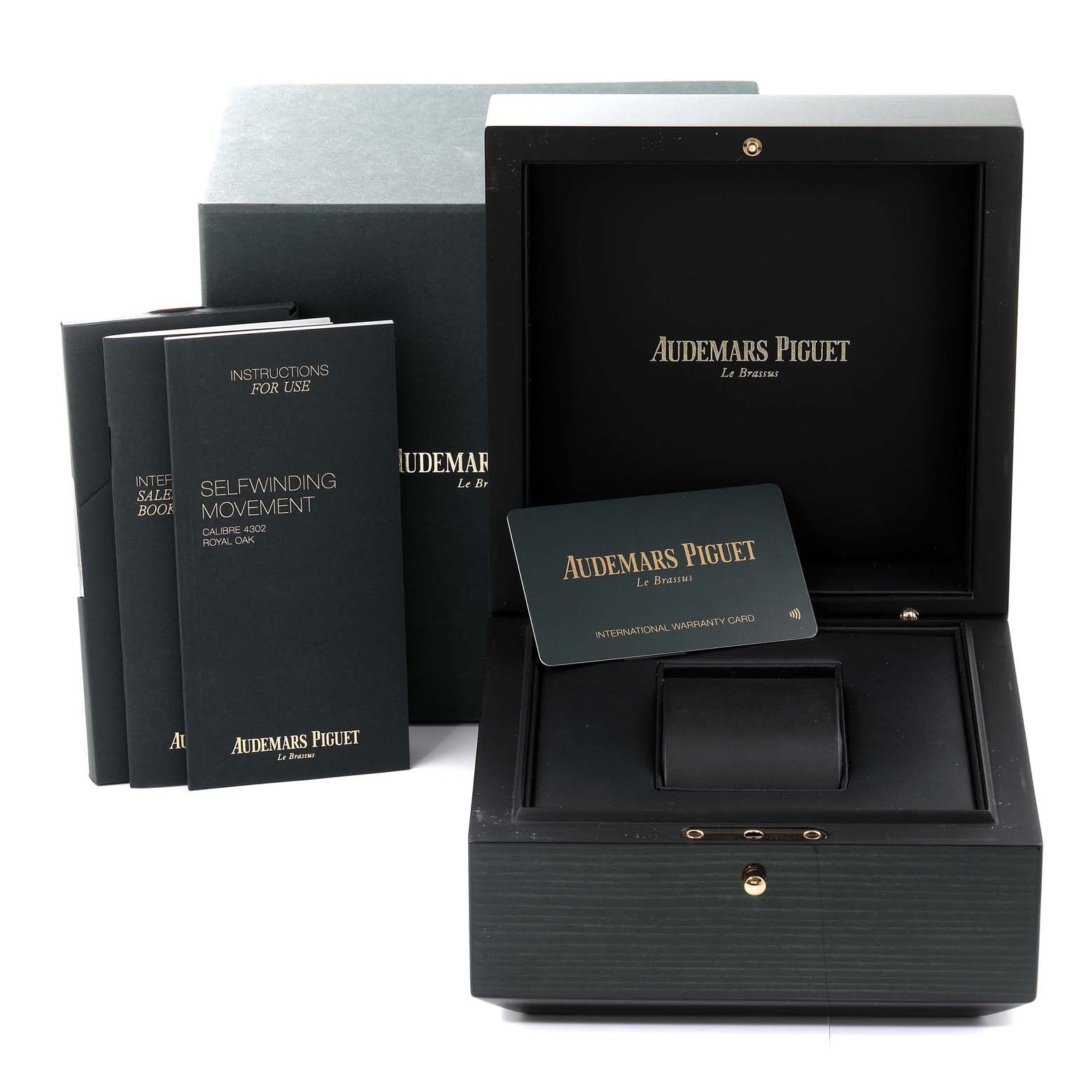 The image shows an open box for the Royal Oak model by Audemars Piguet, along with an international warranty card and instruction booklets.
