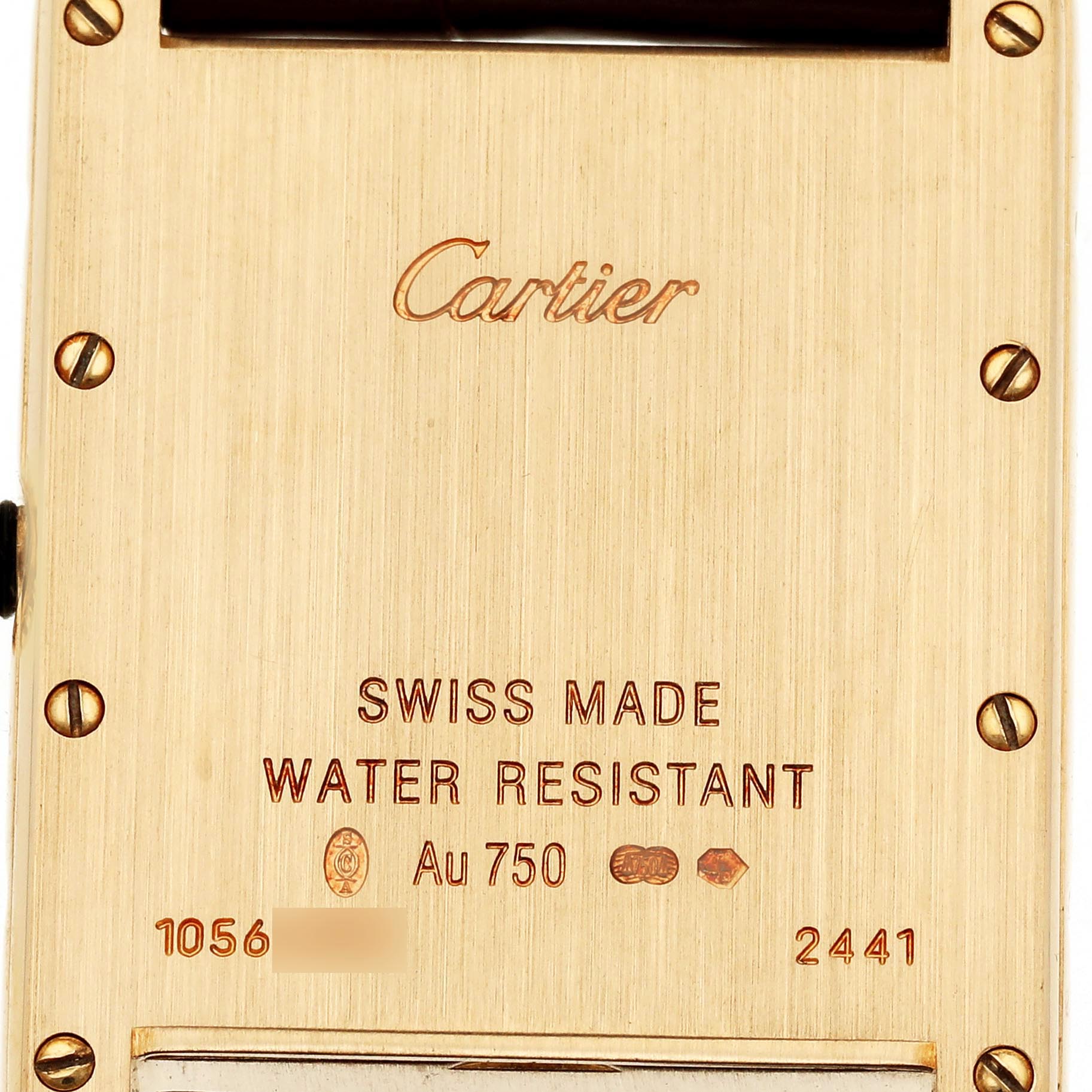 The image shows the back case of a Cartiel Tank Louis watch, featuring engravings and screws.