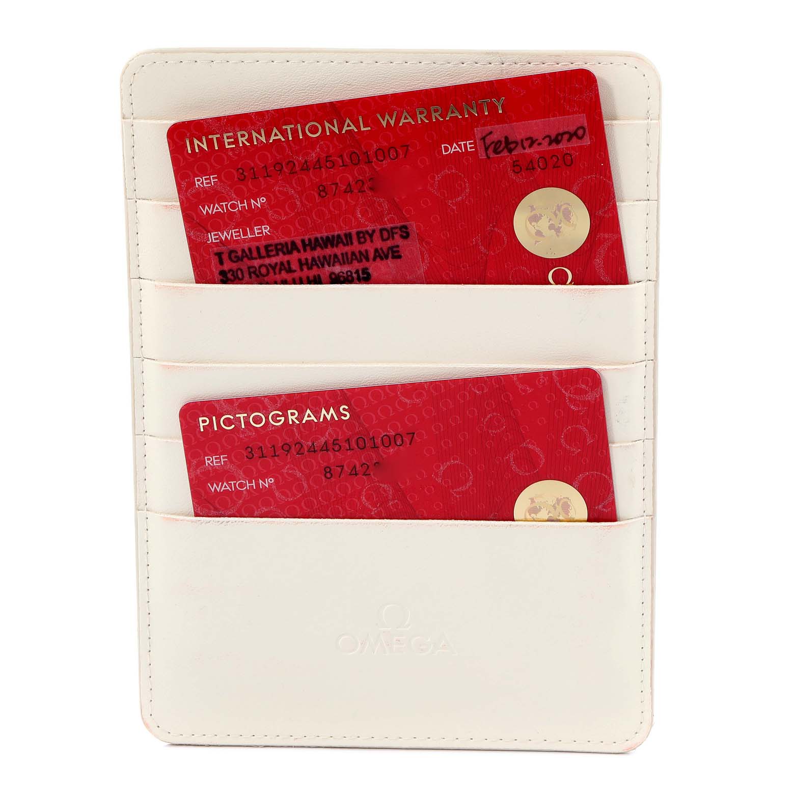 The image shows warranty and pictogram cards in a white Omega holder for a Speedmaster model by Omega.
