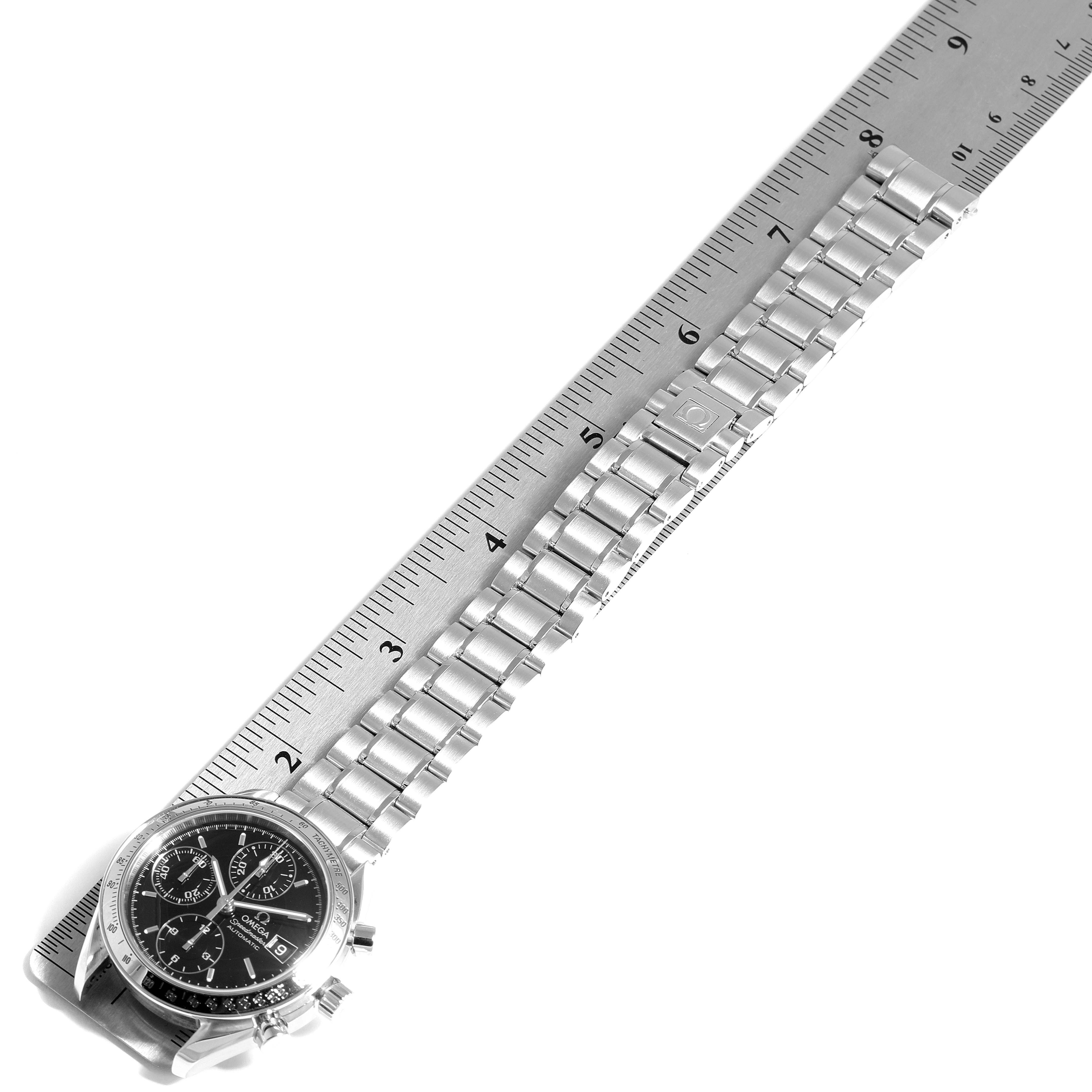 The image shows an Omega Speedmaster 3513.50.00 Men
s Stainless Steel Black Dial 3513.50.00 Men
s Stainless Steel Black Dial watch laid out flat with its bracelet measured by a ruler.