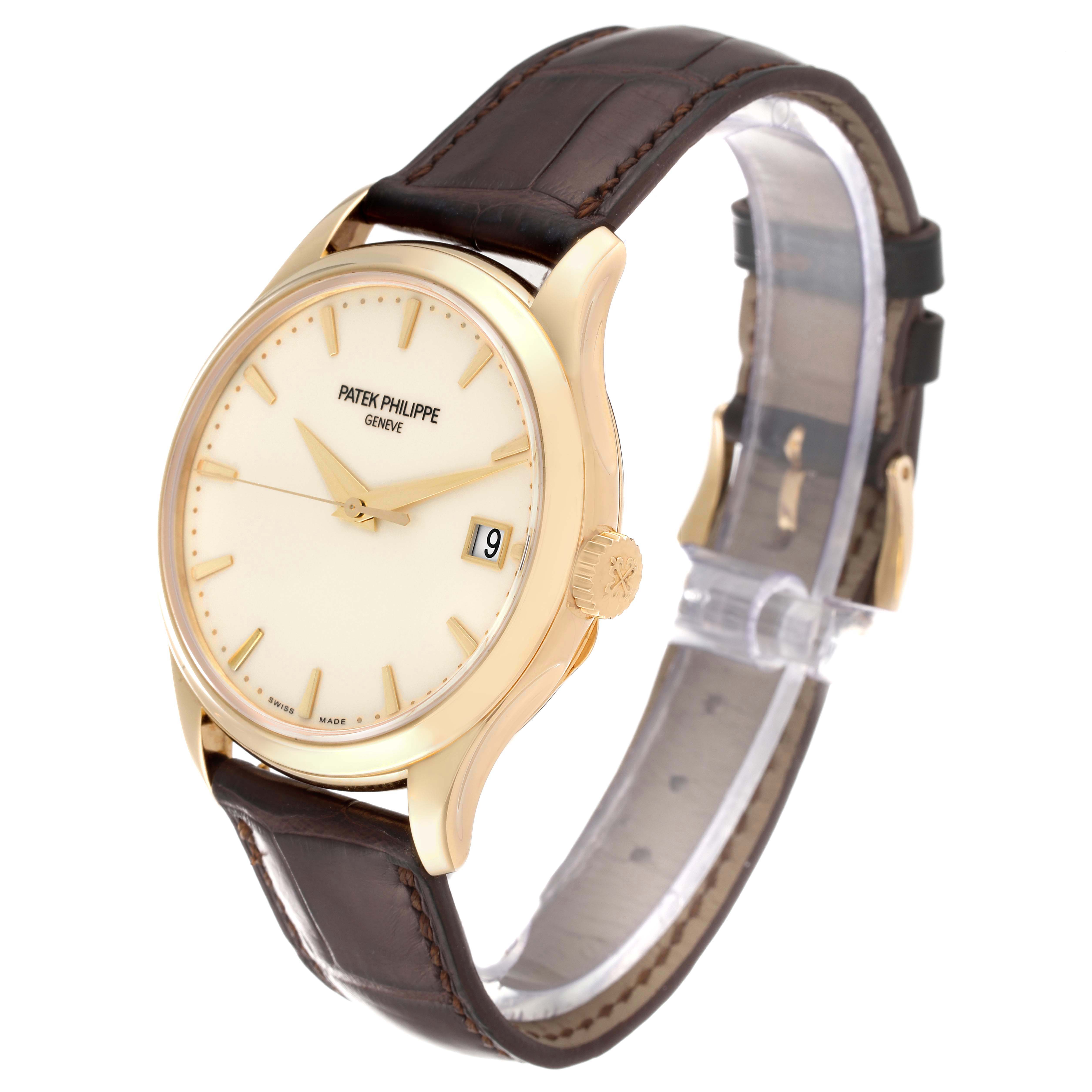 This image shows a Patek Philippe Calatrava 5227J-001 Men's Yellow Gold Beige Dial 5227J-001 Men's Yellow Gold Beige Dial watch at a front-side angle, highlighting the face, dial, crown, and leather strap.