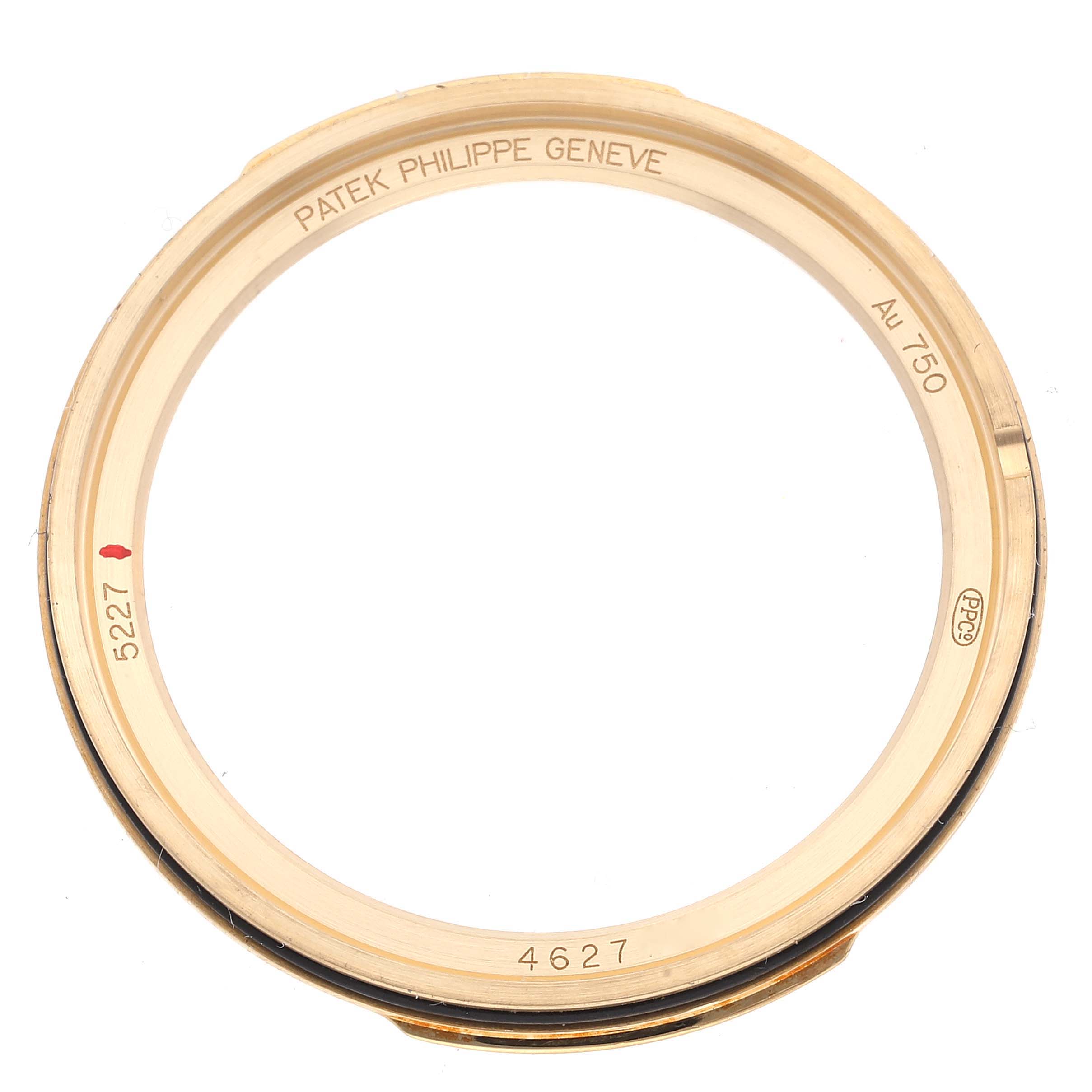 This image shows the bezel of a Patek Philippe Calatrava 5227J-001 Men's Yellow Gold Beige Dial 5227J-001 Men's Yellow Gold Beige Dial watch with model numbers and brand inscription visible.