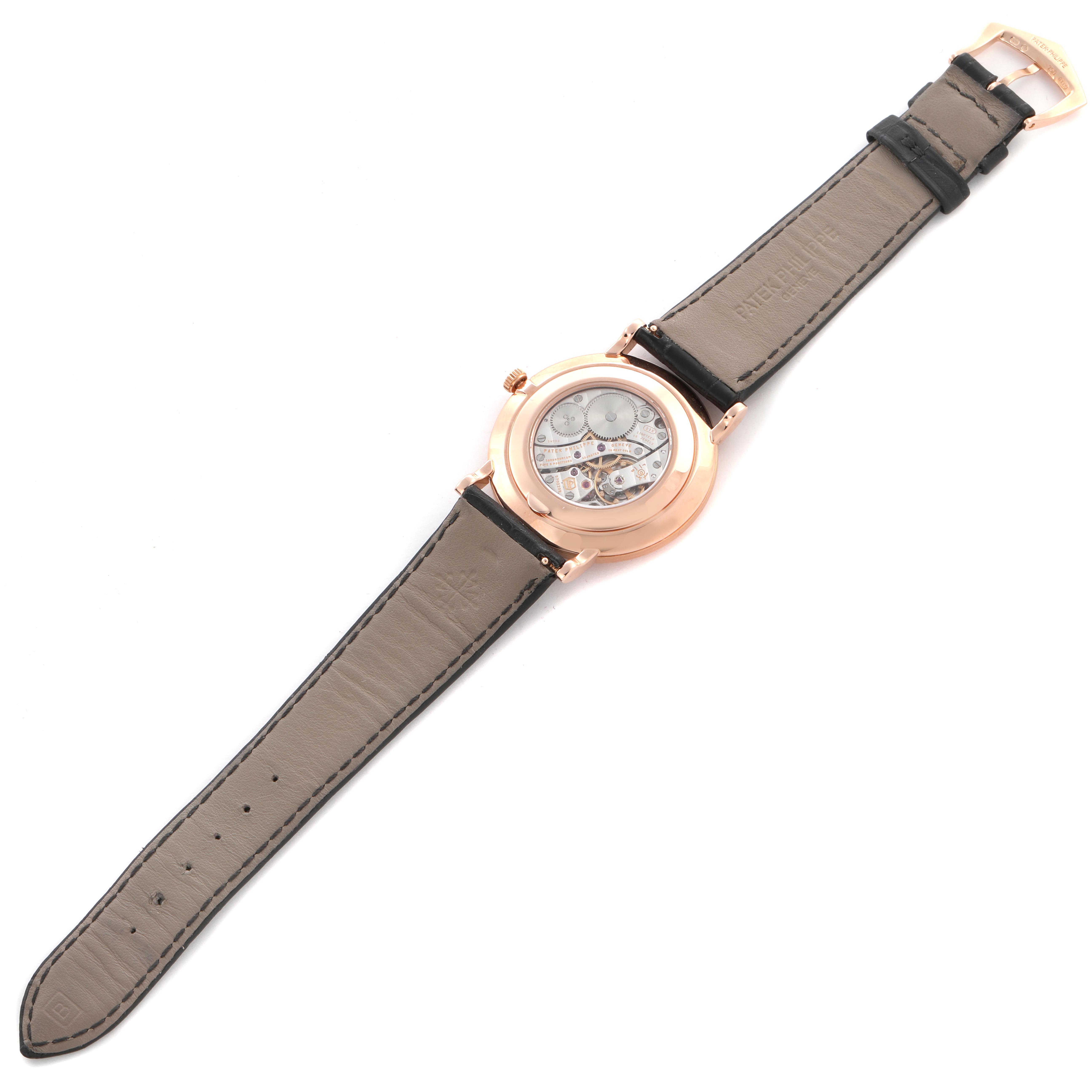 The Patek Philippe Calatrava 5119R Men's Rose Gold White Dial 5119R Men's Rose Gold White Dial watch is shown from the back, displaying the movement through a transparent case back and a leather strap.