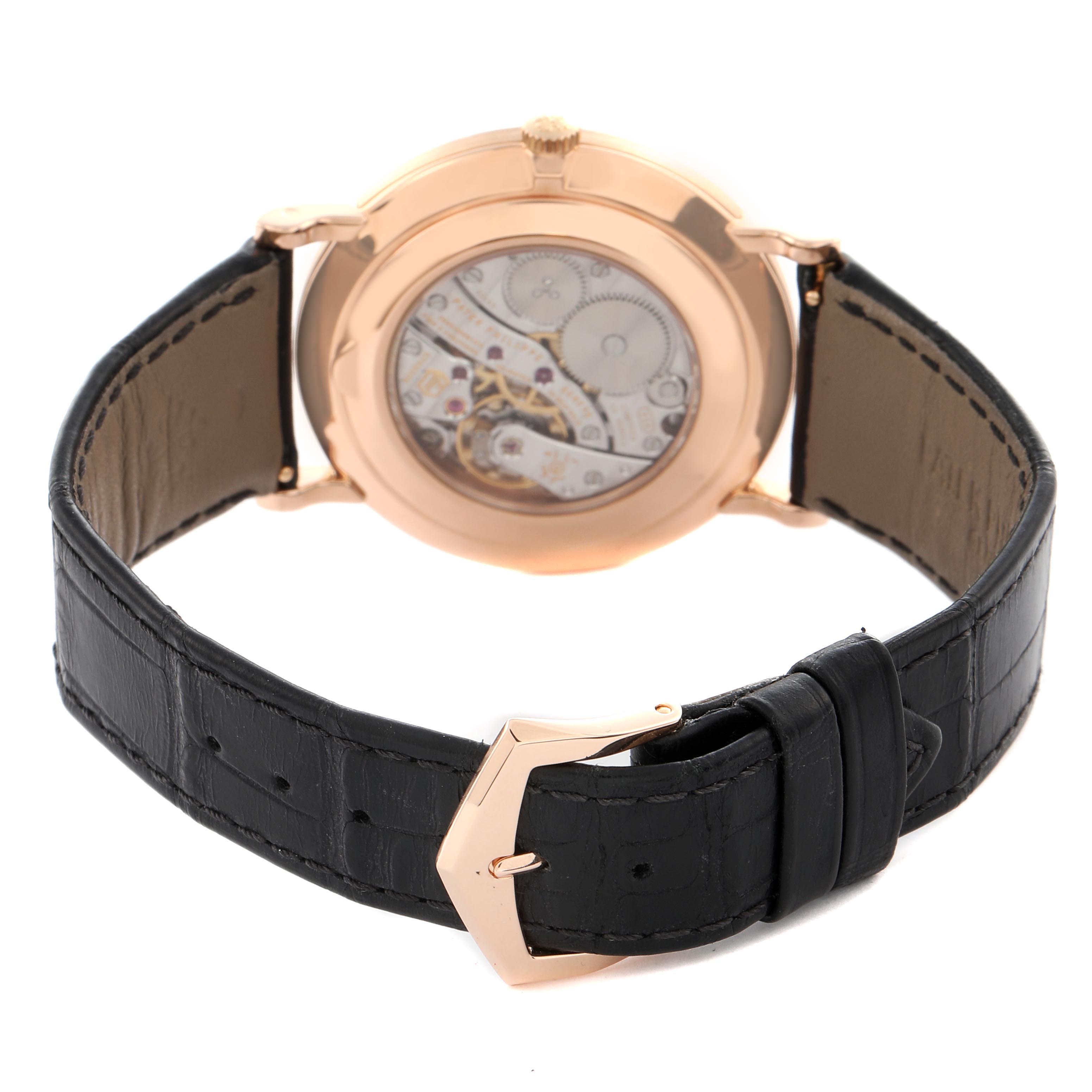 The image shows the back of a Patek Philippe Calatrava 5119R Men's Rose Gold White Dial 5119R Men's Rose Gold White Dial watch, highlighting its movement and black leather strap with a rose gold buckle.