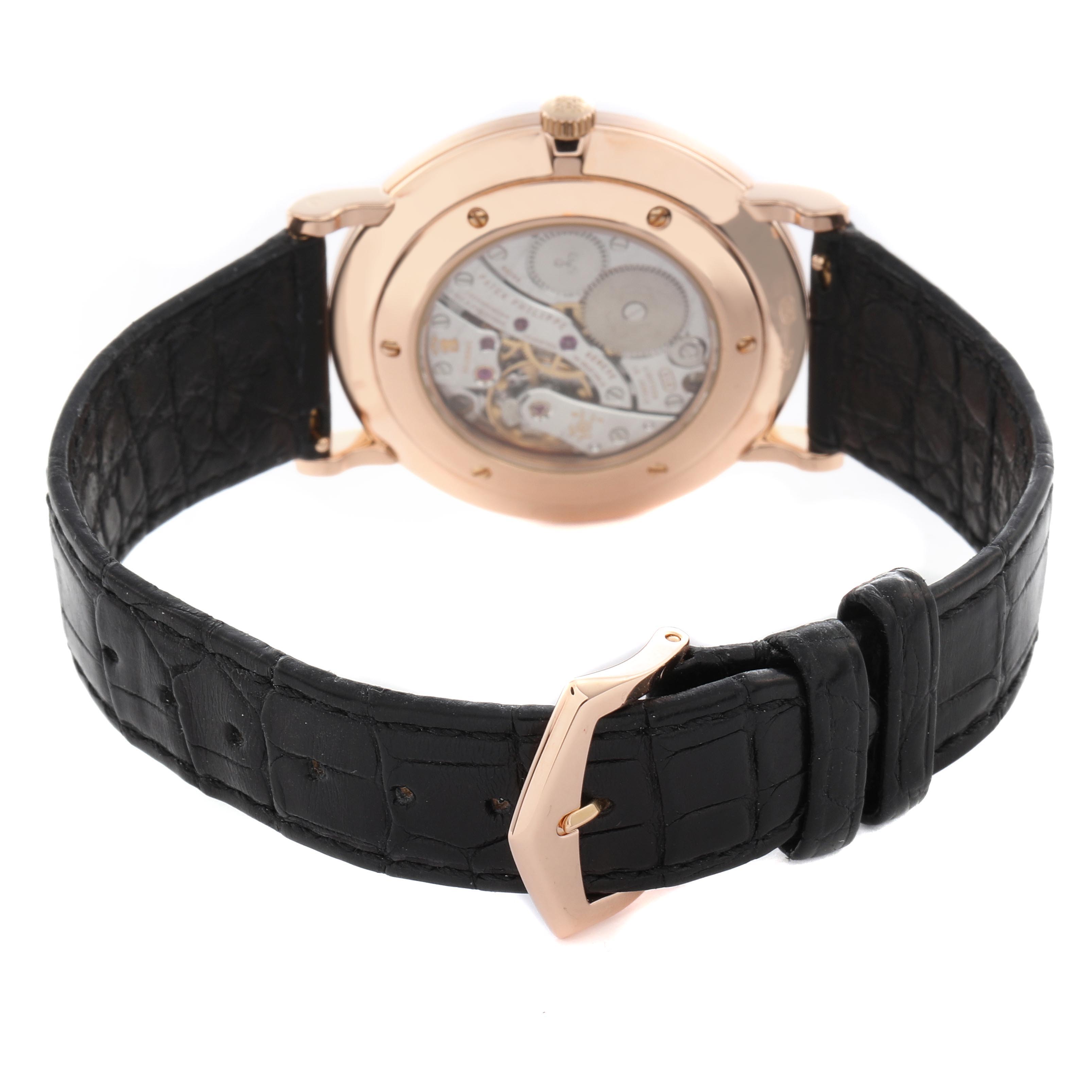 The Patek Philippe Calatrava 5119R Men's Rose Gold White Dial 5119R Men's Rose Gold White Dial is shown from the back, displaying the movement and a black leather strap with a buckle.