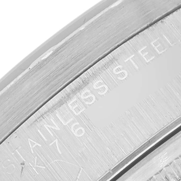 The image shows a close-up of the edge, with a part of the rim and engraved "STAINLESS STEEL" text on a Rolex Date 15210 Men's Stainless Steel Black Dial 15210 Men's Stainless Steel Black Dial watch.