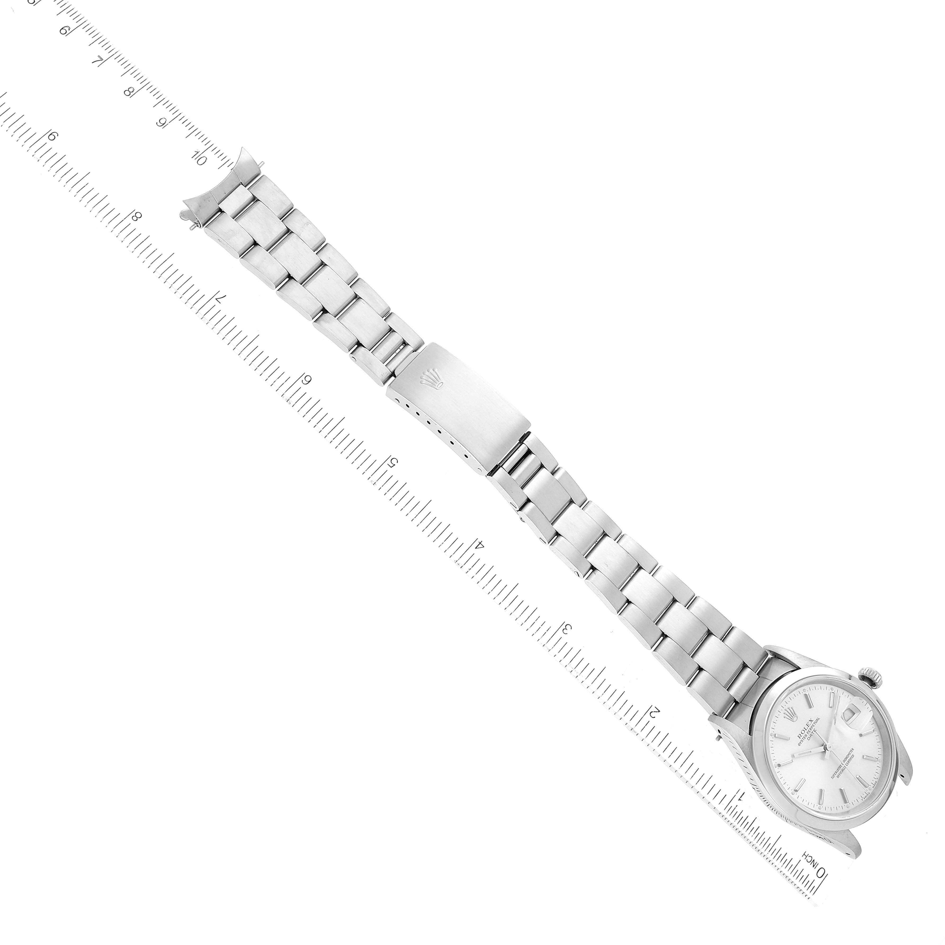 The image shows a Rolex Date 15200 Men
s Stainless Steel Silver Dial 15200 Men
s Stainless Steel Silver Dial model watch laid flat next to a ruler, displaying its face, bracelet, and clasp.