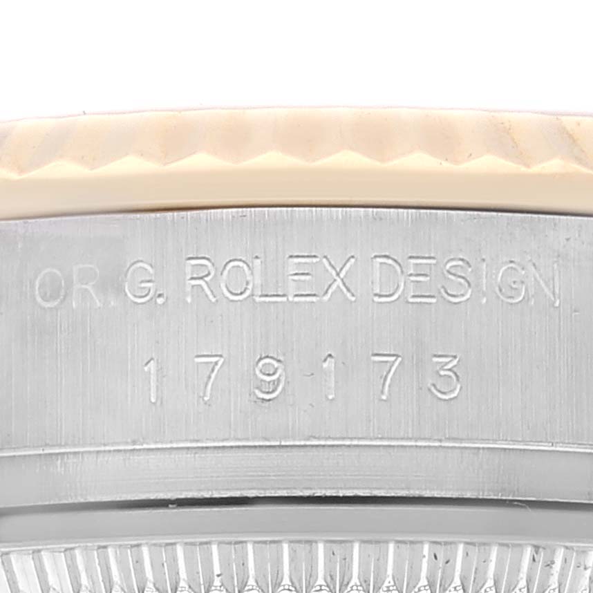 This image shows the side view of the case of a Rolex Datejust 179173 Women's Steel and Gold (two tone) Champagne Dial 179173 Women's Steel and Gold (two tone) Champagne Dial watch, highlighting the engraved model and design numbers.