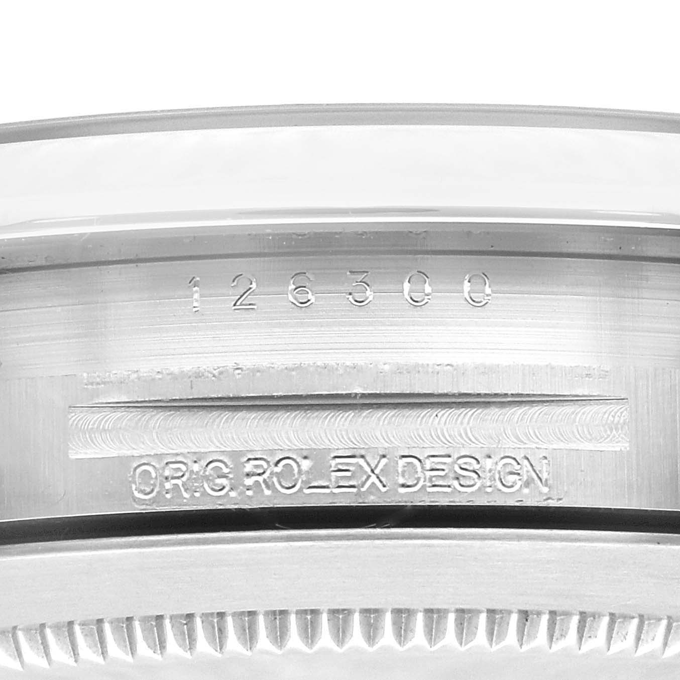 This close-up image of the Rolex Datejust 41 126300 Men
s Stainless Steel Grey Dial 126300 Men
s Stainless Steel Grey Dial shows the serial number and "ORIG. ROLEX DESIGN" engraving on the metal casing.