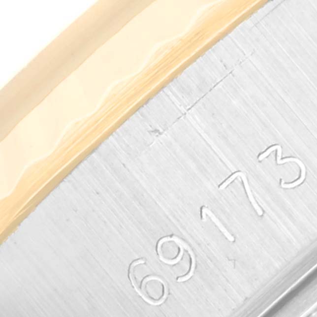 The image shows a close-up of a serial number on the metal case-side of a Rolex Datejust 69173 Women
s Steel and Gold (two tone) Champagne Dial 69173 Women
s Steel and Gold (two tone) Champagne Dial watch.