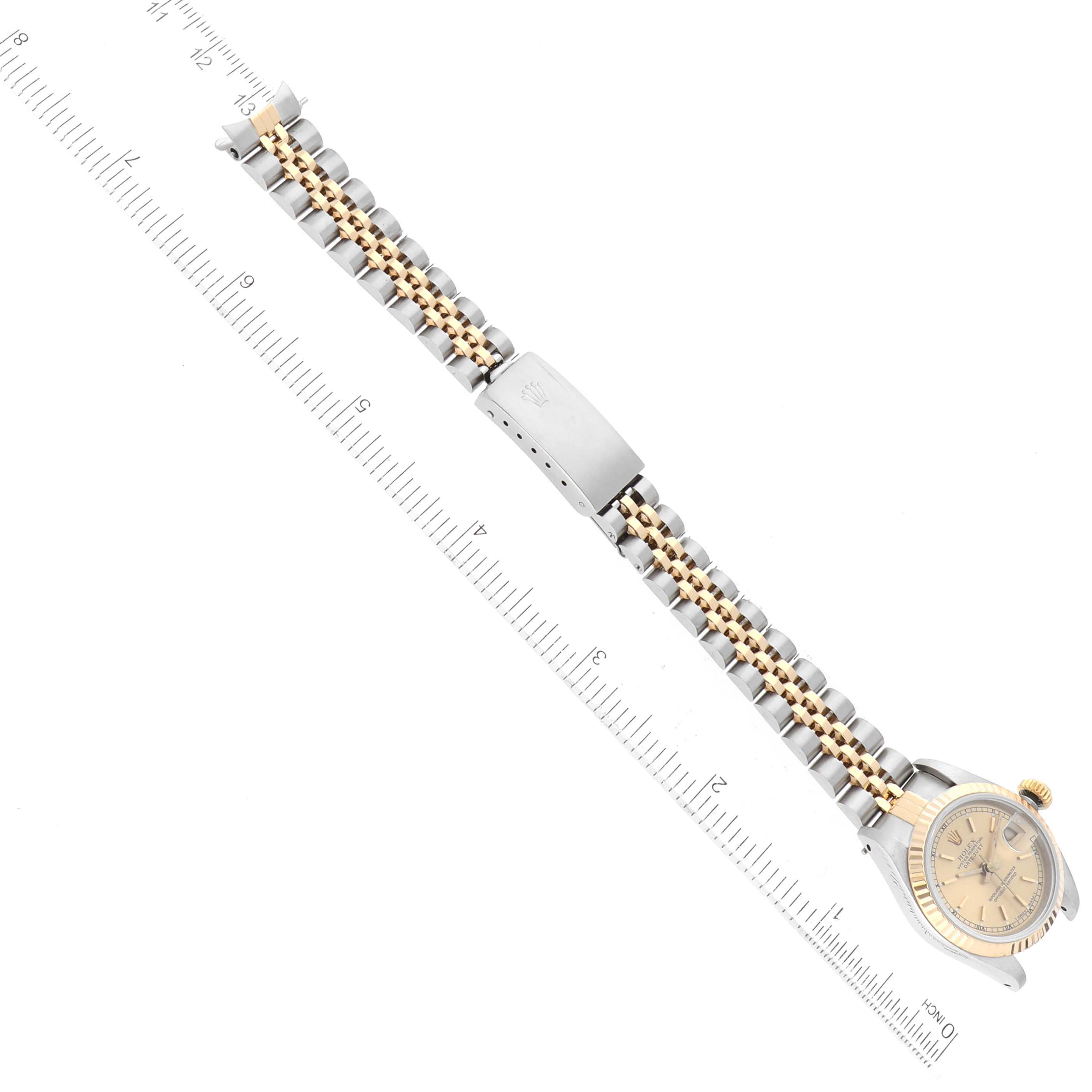 The image shows a Rolex Datejust 69173 Women
s Steel and Gold (two tone) Champagne Dial 69173 Women
s Steel and Gold (two tone) Champagne Dial watch laid flat with its bracelet extended, featuring a two-tone band and a closed clasp.