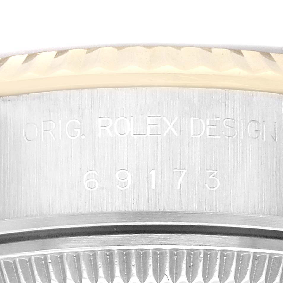 This image shows a close-up of the side engraving on the case of a Rolex Datejust 69173G Women's Steel and Gold (two tone) Champagne Dial 69173G Women's Steel and Gold (two tone) Champagne Dial watch, displaying "ORIG. ROLEX DESIGN 69173".