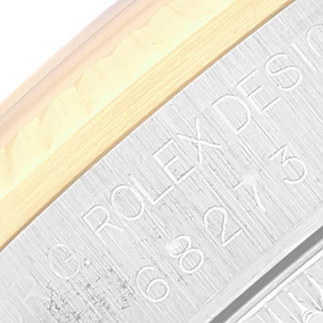 This image shows a close-up of the side of the case of a Mid-Size Rolex watch including engraved details.