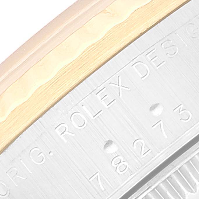 This close-up image shows the engraved edge of the Mid-Size Rolex watch case, including part of the bezel and the serial number.