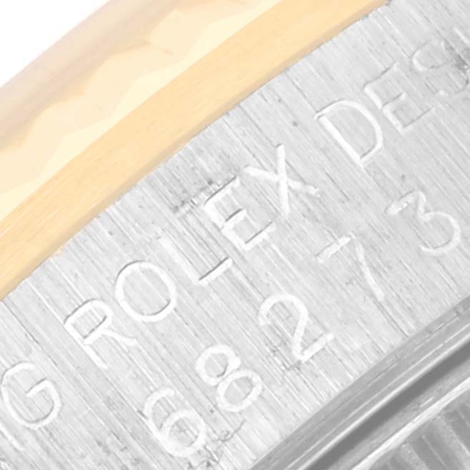 The image shows a close-up angle of the side engraving on a Rolex Mid-Size 68273 Women's Steel and Gold (two tone) Champagne Dial 68273 Women's Steel and Gold (two tone) Champagne Dial model's case with part of the bezel visible.