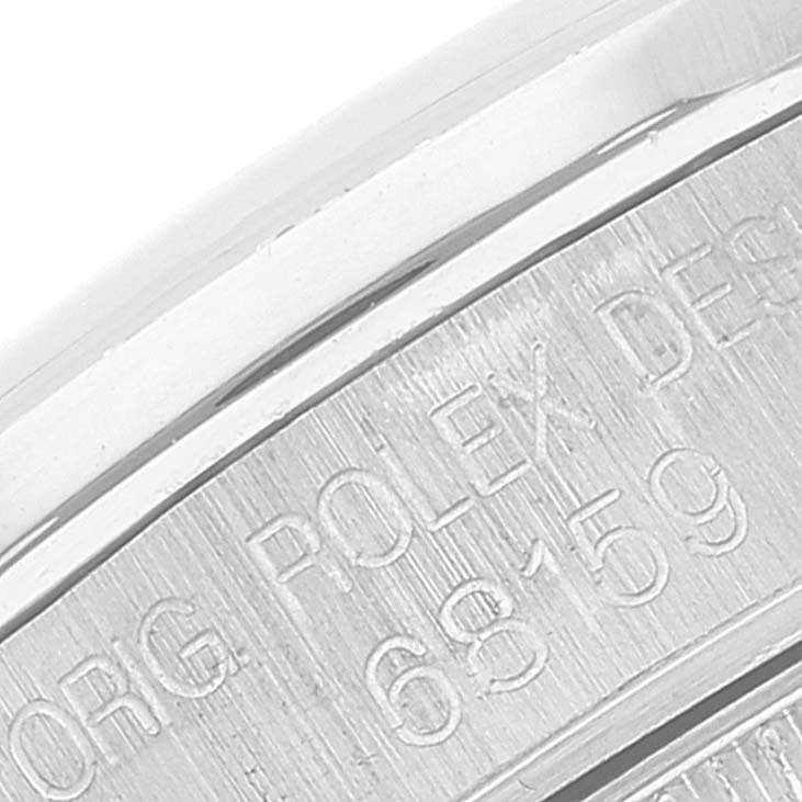 The image shows a close-up of the edge and engravings on the back of a Mid-Size Rolex watch.